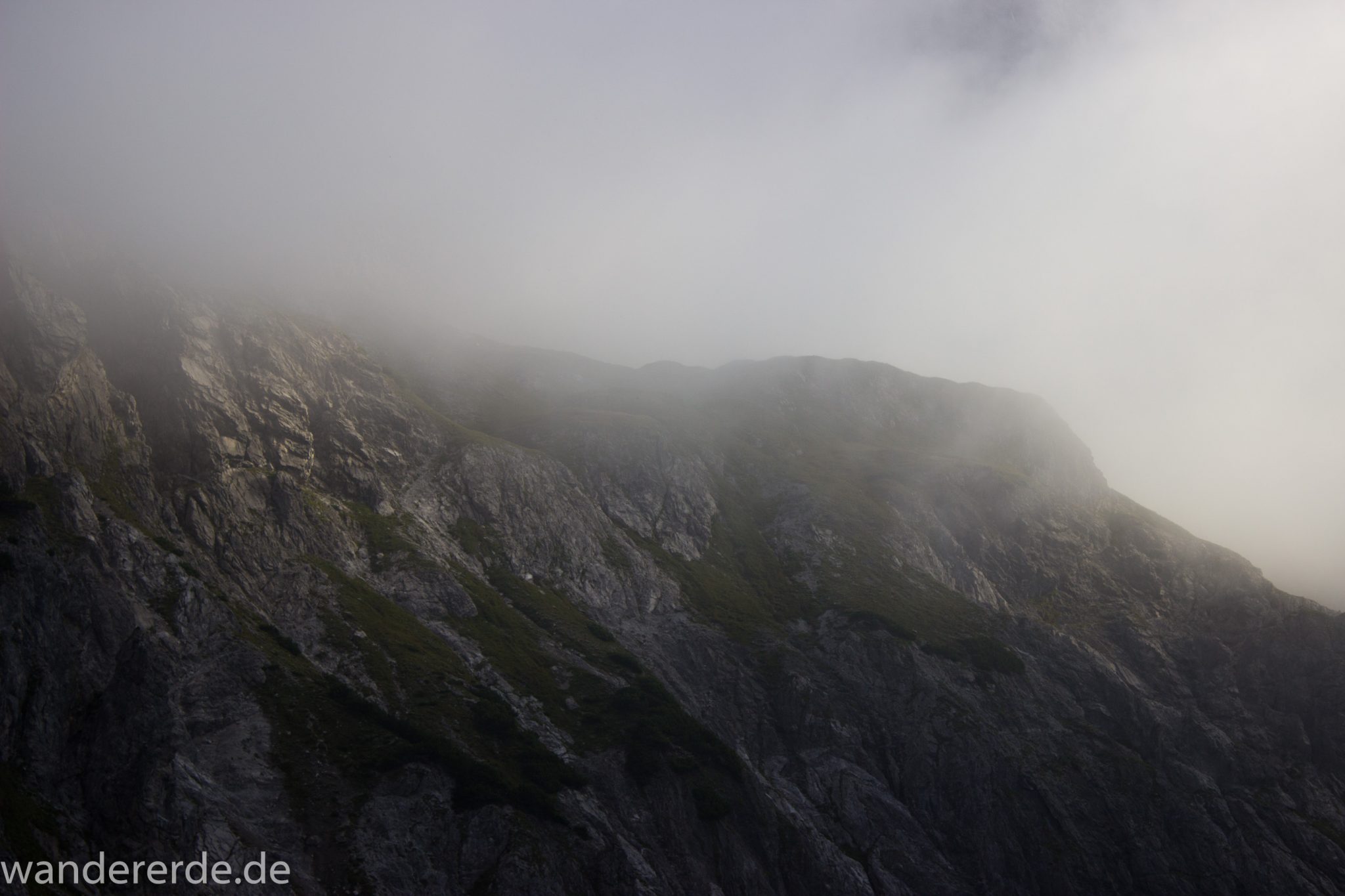 Alpenüberquerung Fernwanderweg E5 Oberstdorf Meran, 2. Etappe von Kemptner Hütte zur Memminger Hütte, in der Nähe vom Mädelejoch, umliegende Berge in Wolken gehüllt, Berggipfel nur teilweise sichtbar, Wanderung mit eingeschränkter Sicht wegen Nebel, beeindruckende Landschaft in den Bergen, bezaubernde Alpen