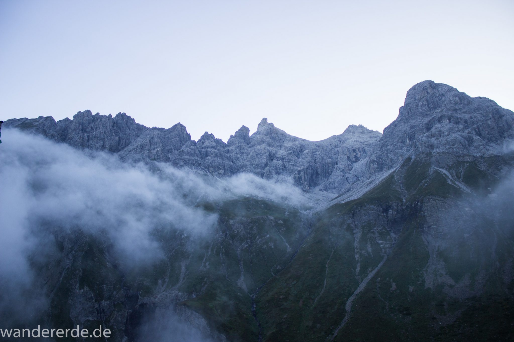 Alpenüberquerung Fernwanderweg E5 Oberstdorf Meran, 2. Etappe von Kemptner Hütte zur Memminger Hütte, kurz nach Sonnenaufgang in den Alpen bei der Kemptner Hütte, Aussicht auf schöne Bergkette, Nebelfelder ziehen ab