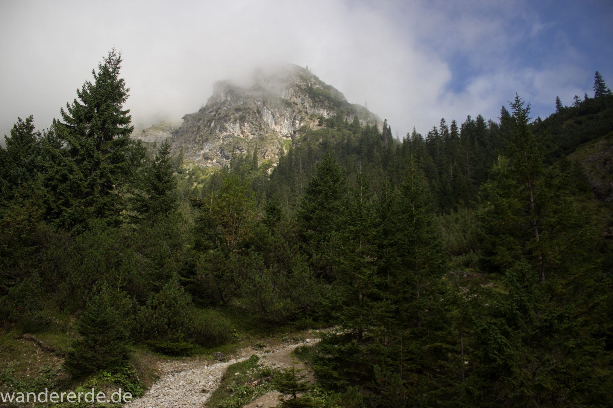 Alpenüberquerung Fernwanderweg E5 Oberstdorf Meran, 2. Etappe von Kemptner Hütte zur Memminger Hütte, schöner und abwechslungsreicher Wanderweg führt absteigend über die Obere und Untere Rossgumpenalpe in das sehr schöne Höhenbachtal mit beeindruckender Landschaft, grüne Vegetation mit Bäumen und Wiesen, Blick auf in Wolken gehüllten Berggipfel