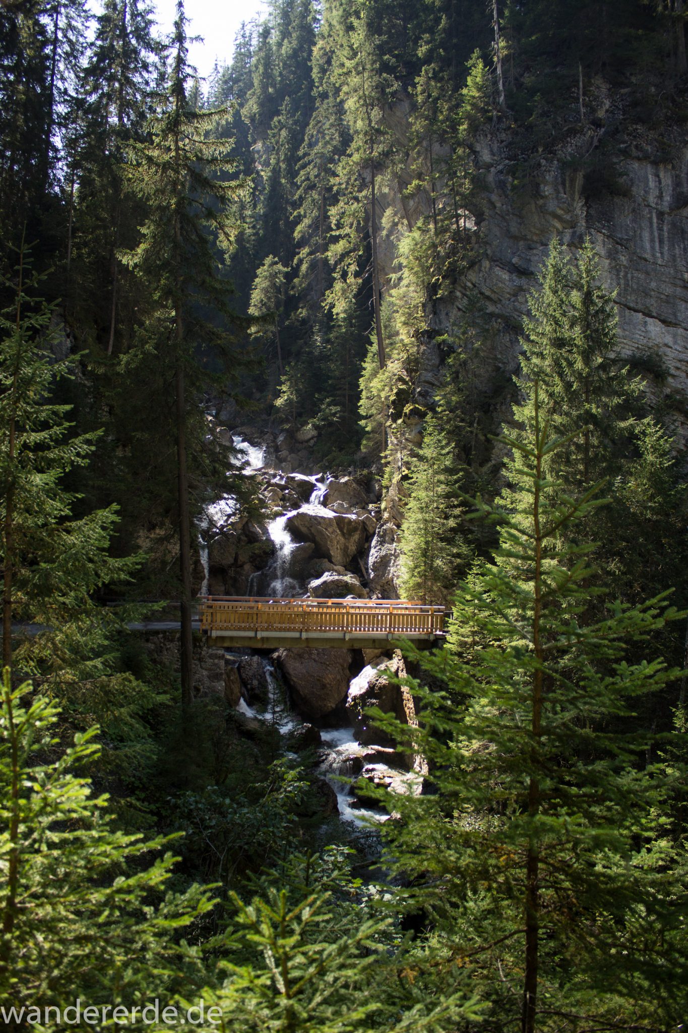 Alpenüberquerung Fernwanderweg E5 Oberstdorf Meran, 2. Etappe von Kemptner Hütte zur Memminger Hütte, schöner Wanderweg führt ab Ort Bach Winkl durch das schöne Madautal mit idyllischer Landschaft und grüner Vegetation, Bach fließt durch Tal, Wanderweg führt bis zur Materialseilbahn der Memminger Hütte, Blick auf Holzbrücke im Madautal