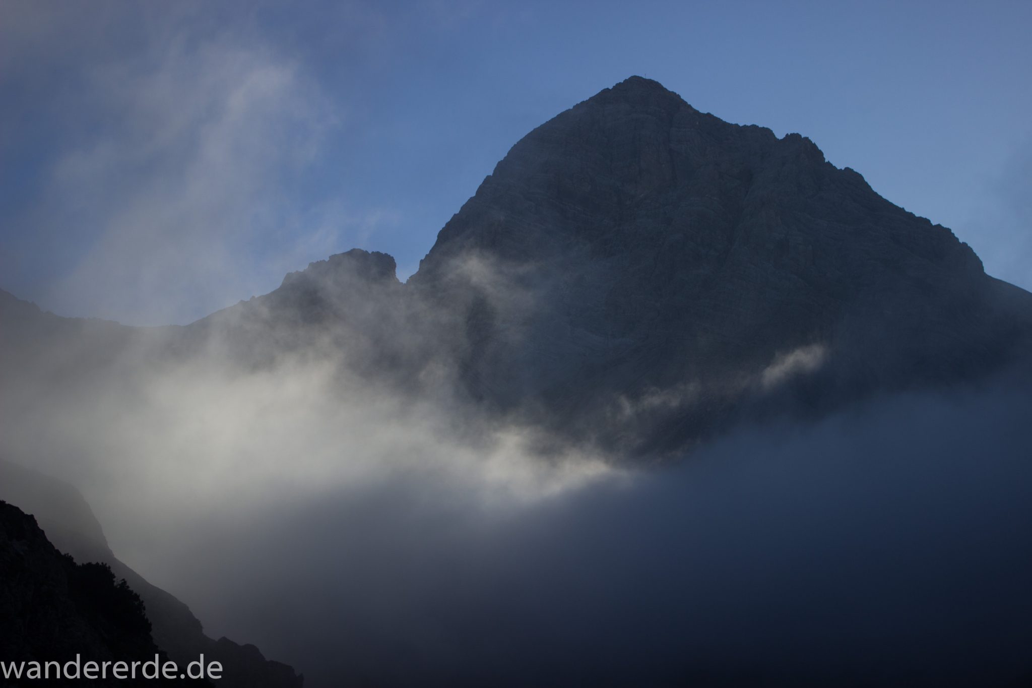 Alpenüberquerung Fernwanderweg E5 Oberstdorf Meran, 2. Etappe von Kemptner Hütte zur Memminger Hütte, Aussicht in der Nähe vom Mädelejoch, umliegende Berge in Wolken gehüllt, Berggipfel sichtbar, weitere Wanderung mit eingeschränkter Sicht wegen Nebel, beeindruckende Landschaft in den Bergen