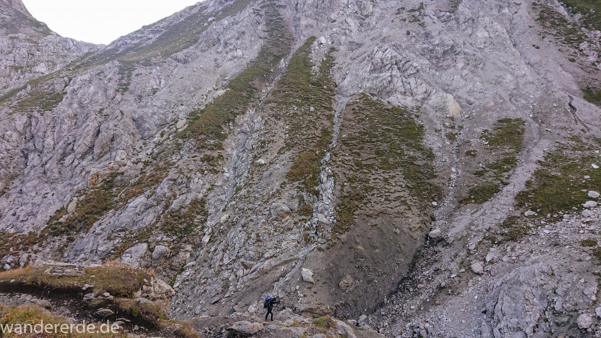 Alpenüberquerung Fernwanderweg E5 Oberstdorf Meran, 3. Etappe von Memminger Hütte zur Skihütte Zams, E5 Wanderweg führt zu Beginn der dritten Etappe ab der Memminger Hütte über steilen und ausgesetzten Wanderweg über die Seescharte, Blick auf Wanderer während Aufstieg zur Seescharte auf sehr schmalem Wanderweg über viel Geröll, steile Berghänge der Alpen