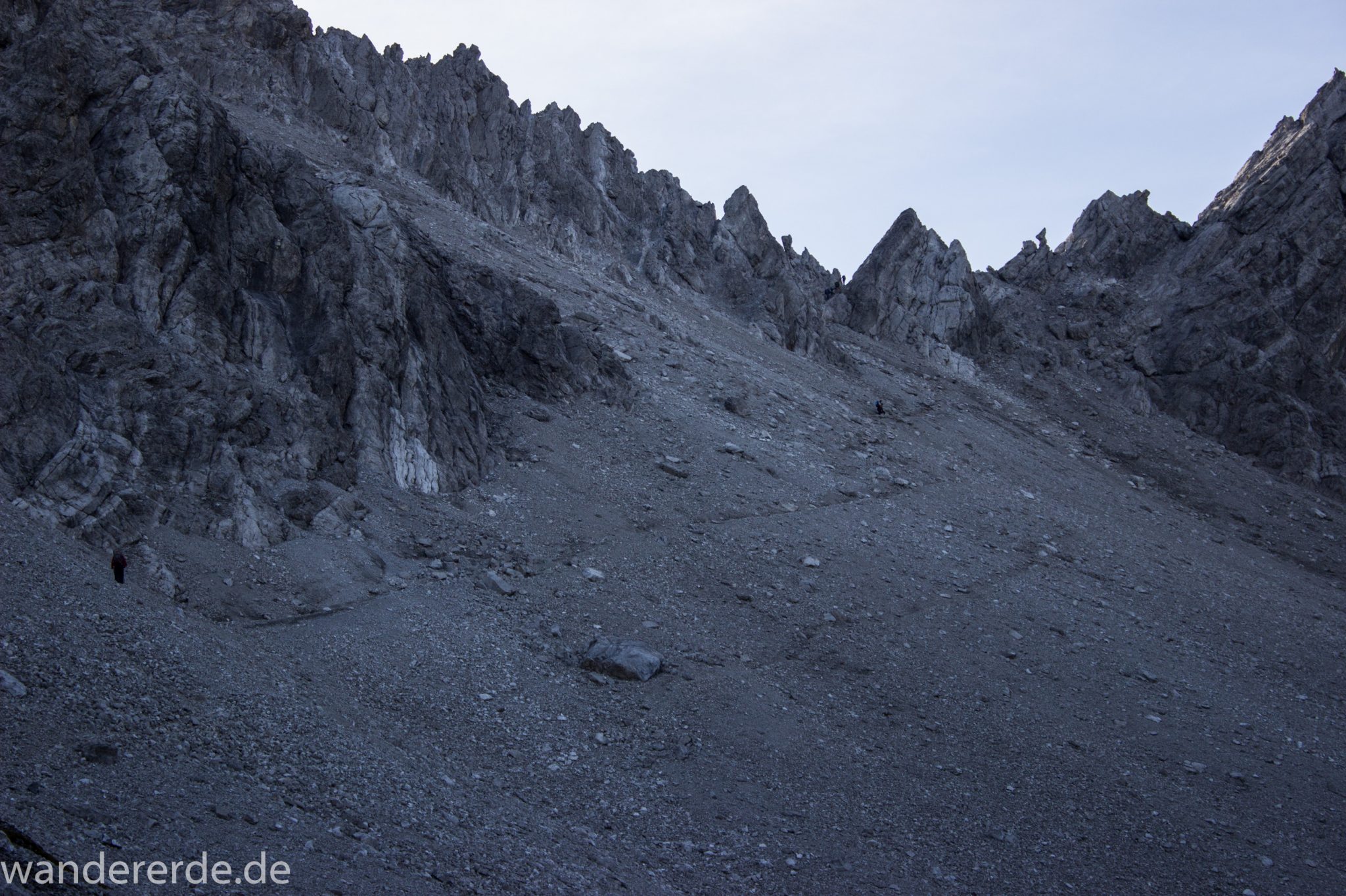 Alpenüberquerung Fernwanderweg E5 Oberstdorf Meran, 3. Etappe von Memminger Hütte zur Skihütte Zams, E5 Wanderweg führt zu Beginn der dritten Etappe ab der Memminger Hütte über steilen und ausgesetzten Wanderweg über die Seescharte, Blick auf Wanderer während Aufstieg zur Seescharte auf sehr schmalem Wanderweg über viel Geröll, steile Berghänge und Gipfel der Alpen