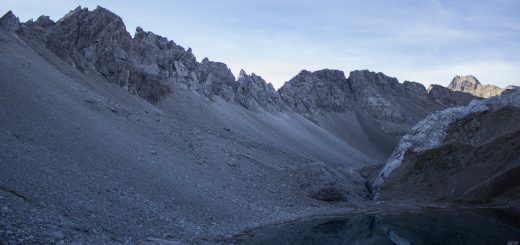 Alpenüberquerung Fernwanderweg E5 Oberstdorf Meran, 3. Etappe von Memminger Hütte zur Skihütte Zams, E5 Wanderweg führt zu Beginn der dritten Etappe ab der Memminger Hütte über steilen und ausgesetzten Wanderweg über die Seescharte, Blick auf kristallklaren Bergsee während Aufstieg zur Seescharte auf sehr schmalen Wanderweg über viel Geröll, Aussicht auf Berge der Alpen