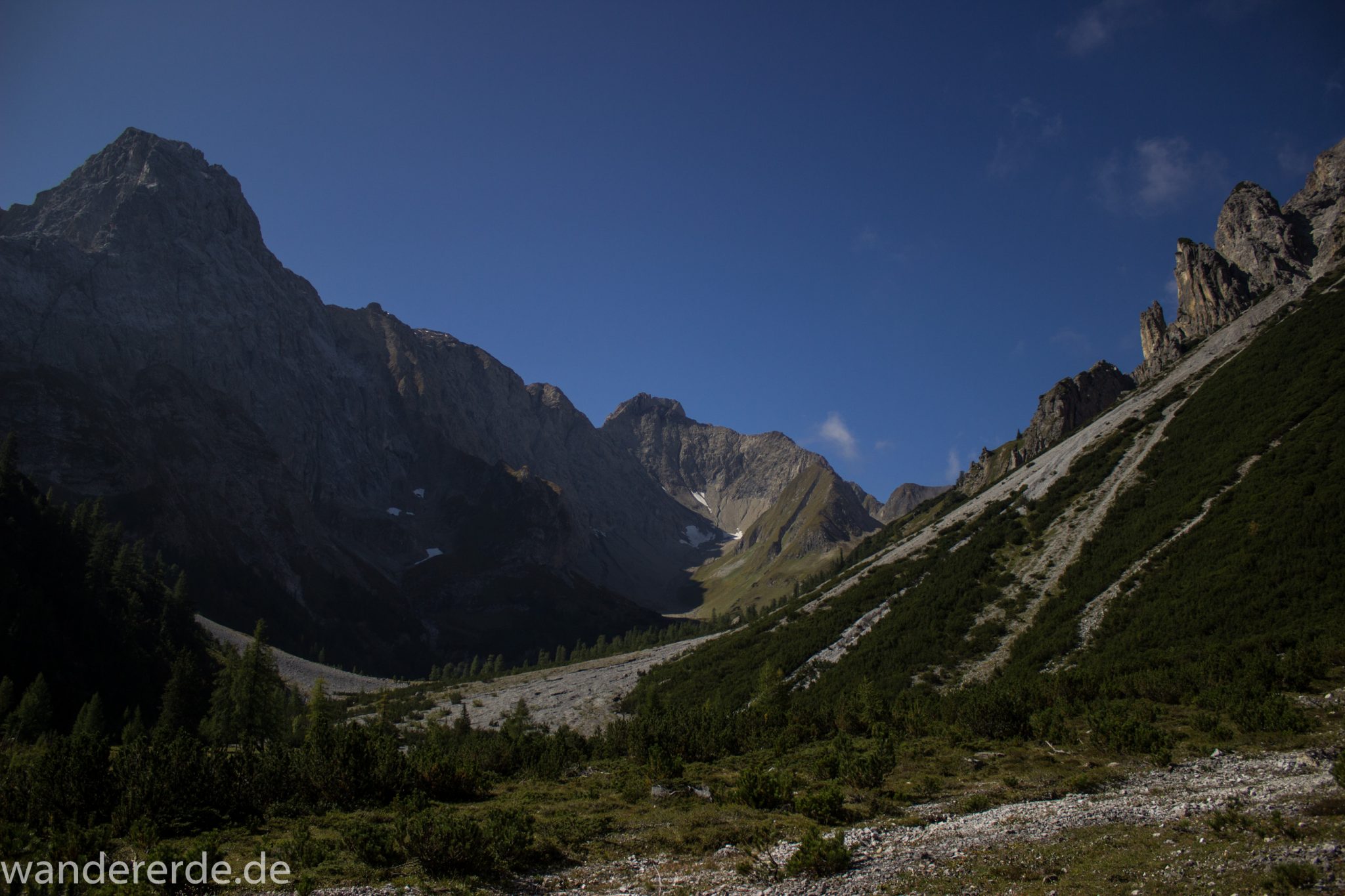 Alpenüberquerung Fernwanderweg E5 Oberstdorf Meran, 3. Etappe von Memminger Hütte zur Skihütte Zams, nach Erreichen der Seescharte folgt ein sehr langer Abstieg auf schmalem Wanderpfad ins Lochbachtal Richtung Zams, Aussicht auf beeindruckende Berge der Alpen und Bergwiesen, grüne Vegetation ist wieder erreicht