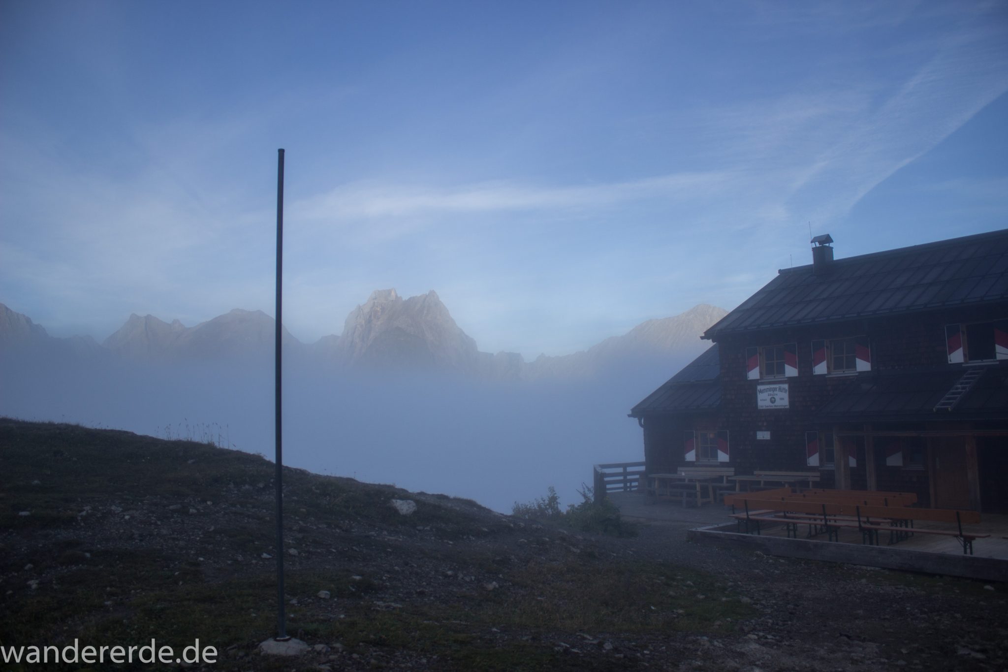 Alpenüberquerung Fernwanderweg E5 Oberstdorf Meran, 3. Etappe von Memminger Hütte zur Skihütte Zams, Berge sind am frühen Morgen noch in Nebel getaucht, aber die Sonne scheint, herrliches Wetter zum Wandern, Blick auf die Memminger Hütte und umliegende Berge der Alpen