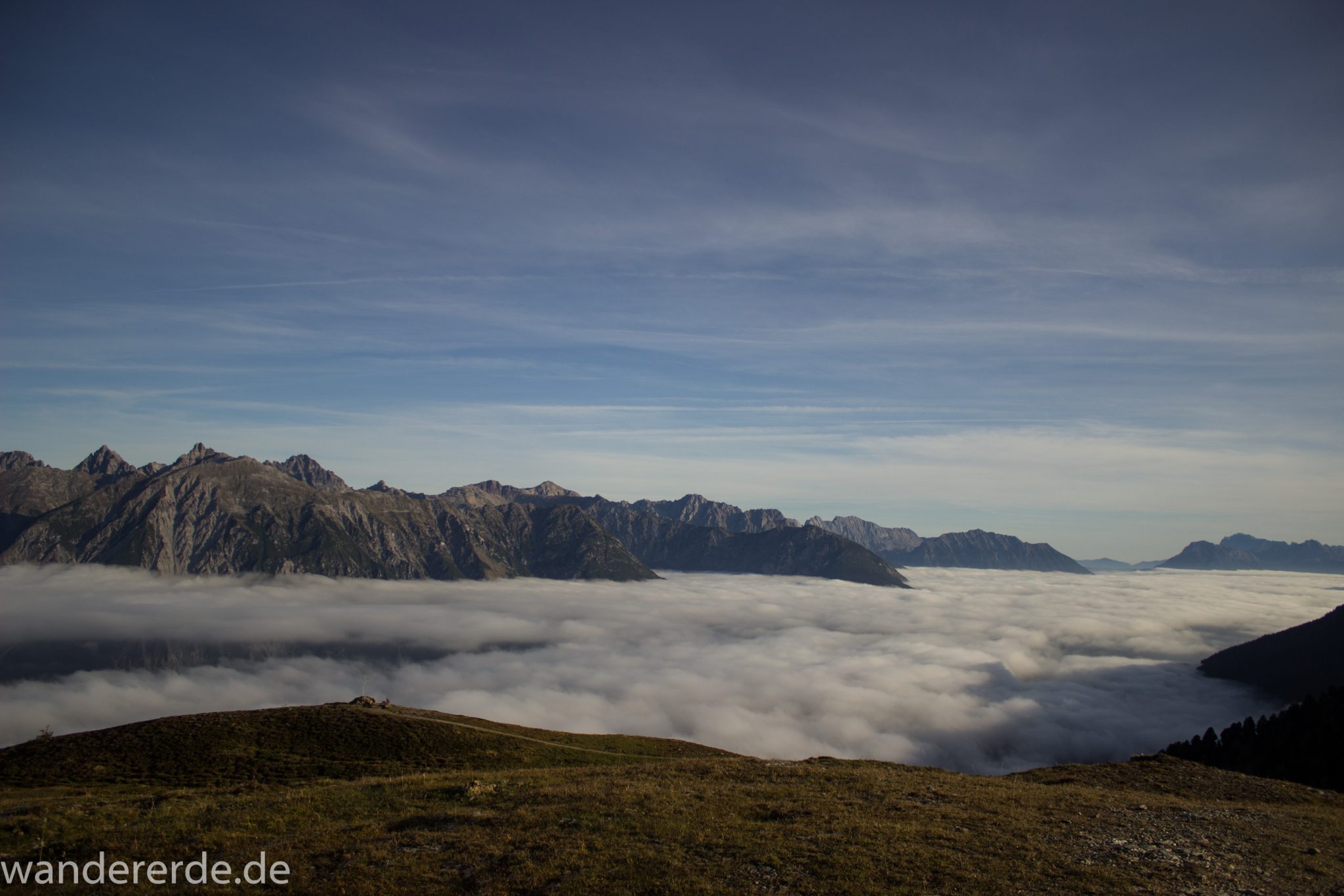 Alpenüberquerung Fernwanderweg E5 Oberstdorf Meran, 4. Etappe von Skihütte Zams zur Braunschweiger Hütte, Aussicht bei der Bergstation der Venet Bergbahn auf die Berge der Alpen, sind noch von Nebel umgeben, herrliches Wanderwetter bei strahlendem Sonnenschein