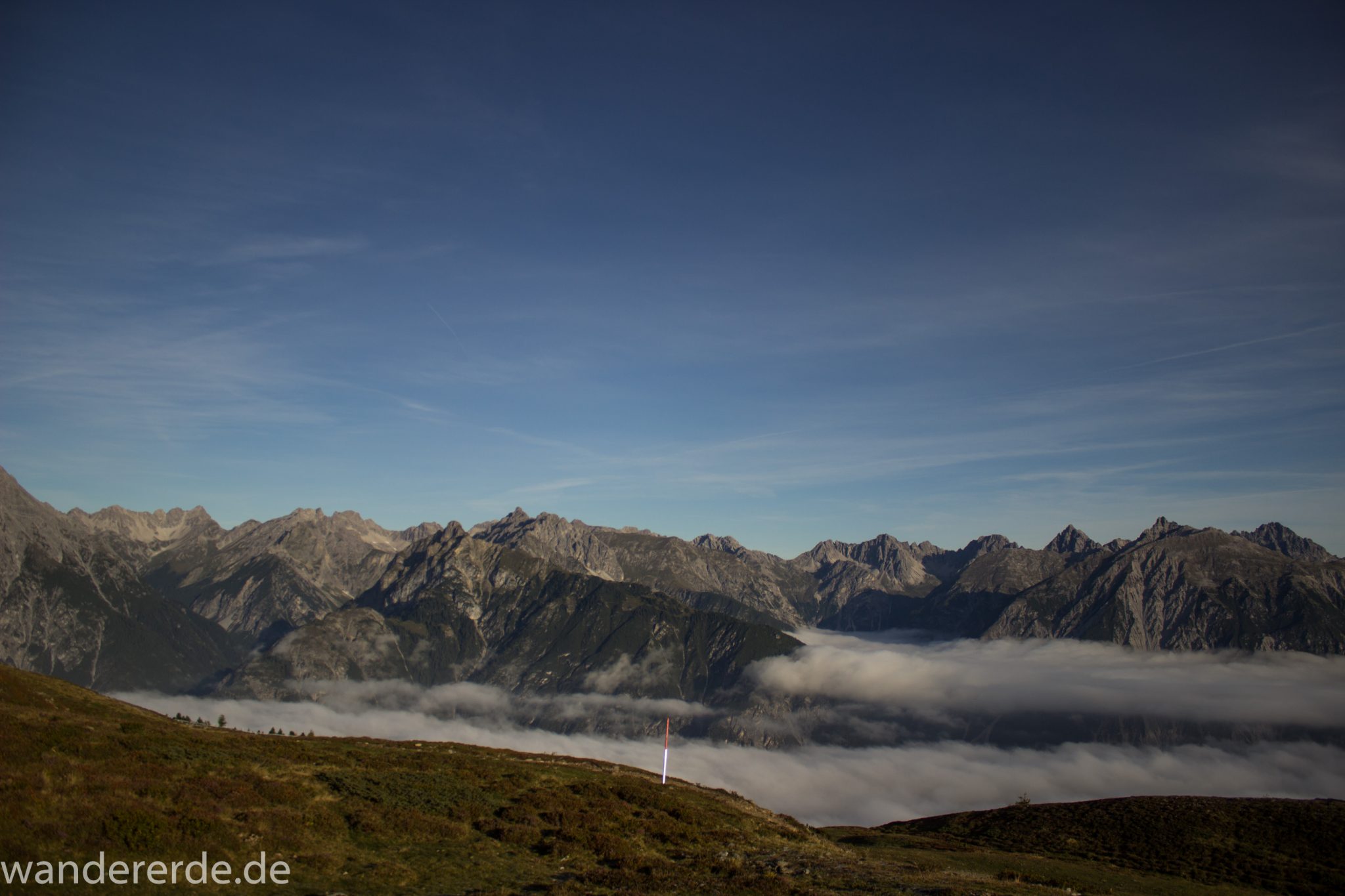 Alpenüberquerung Fernwanderweg E5 Oberstdorf Meran, 4. Etappe von Skihütte Zams zur Braunschweiger Hütte, Aussicht bei der Bergstation der Venet Bergbahn auf die Berge der Alpen, sind noch von Nebel umgeben, herrliches Wanderwetter bei strahlendem Sonnenschein
