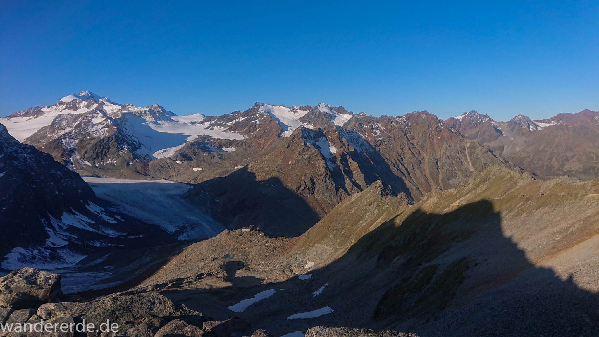 Alpenüberquerung Fernwanderweg E5 Oberstdorf Meran, 5. Etappe von Braunschweiger Hütte zur Martin-Busch-Hütte, zu Beginn der 5. Etappe Blick zurück auf steilen und schmalen Wanderweg mit viel Geröll hinauf zum Pitztaler Jöchl, Ausblick bei Erreichen des Pitztaler Jöchl, sehr beeindruckende Berge in den Alpen mit Resten von Schneefeldern