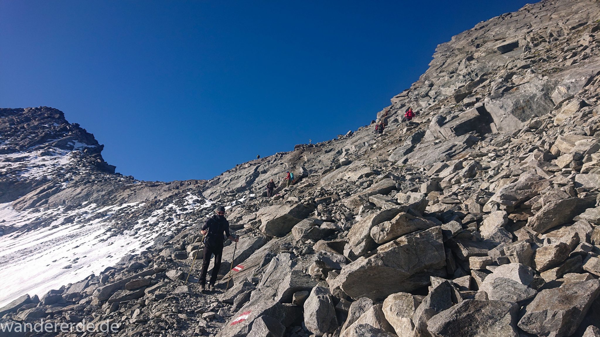 Alpenüberquerung Fernwanderweg E5 Oberstdorf Meran, 5. Etappe von Braunschweiger Hütte zur Martin-Busch-Hütte, zu Beginn der 5. Etappe steiler und schmaler Wanderweg mit viel Geröll hinauf zum Pitztaler Jöchl, nach Erreichen des Pitztaler Jöchl auf anderer Seite sehr steiler Abstieg über grobes Geröll mit teils schwierigen Abschnitten mit Sicherungen durch Drahtseil und Trittstufen aus Metall, sehr beeindruckende Bergwelt in den Alpen mit Resten von Schneefeldern, Wegmarkierung an sehr großen Felsen und Steinen, Abstieg später von einem großen Stein zum nächsten hüpfen, sehr abwechslungsreich