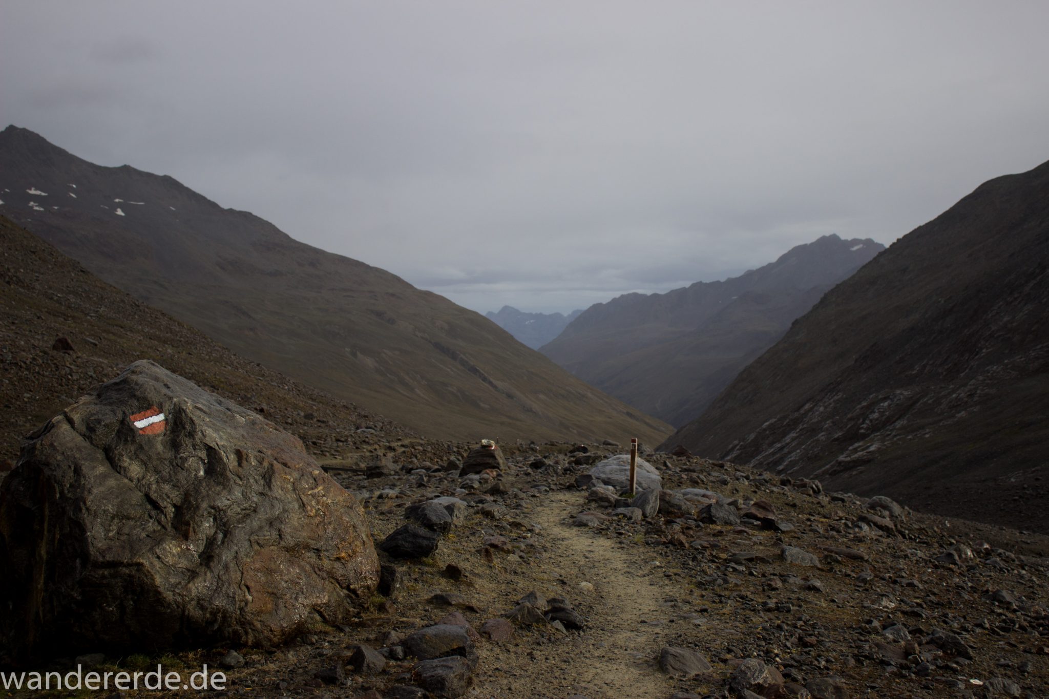 Alpenüberquerung Fernwanderweg E5 Oberstdorf Meran, 6. Etappe von Martin-Busch-Hütte nach Vernagt / Meran, die letzte Etappe der Alpenüberquerung auf dem E5 startet mit dem Aufstieg zur Similaun-Hütte, dem höchsten Punkt der gesamten Alpenüberquerung, umliegende sehr beeindruckende Bergwelt erscheint unwirklich und mystisch, Berghänge mit viel Geröll, Wanderweg verläuft zunächst gering ansteigend neben einem Bach und dann steil bergauf, hier Blick auf Beginn des steilen Abschnitts, Wegmarkierung an großem Stein