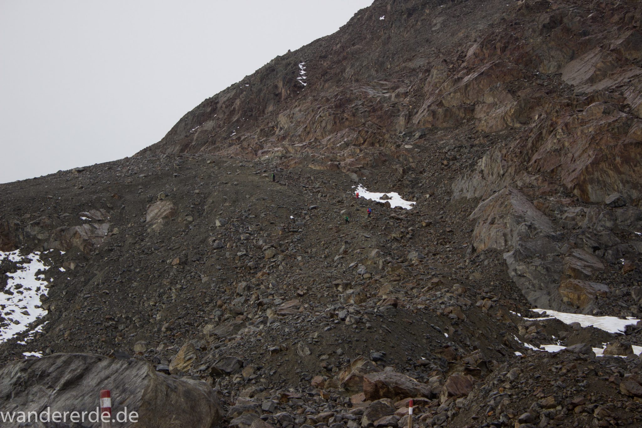 Alpenüberquerung Fernwanderweg E5 Oberstdorf Meran, 6. Etappe von Martin-Busch-Hütte nach Vernagt / Meran, die letzte Etappe der Alpenüberquerung auf dem E5 startet mit dem Aufstieg zur Similaun-Hütte, dem höchsten Punkt der gesamten Alpenüberquerung, umliegende sehr beeindruckende Bergwelt erscheint unwirklich und mystisch, Berghänge mit viel Geröll, Wanderweg verläuft zunächst gering ansteigend neben einem Bach und dann steil bergauf, Blick auf Wanderer auf steilem Abschnitt