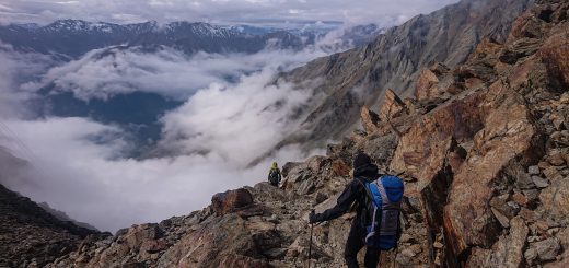 Alpenüberquerung Fernwanderweg E5 Oberstdorf Meran, 6. Etappe von Martin-Busch-Hütte nach Vernagt / Meran, die letzte Etappe der Alpenüberquerung auf dem E5 startet mit dem Aufstieg zur Similaun-Hütte, dem höchsten Punkt der gesamten Alpenüberquerung, umliegende sehr beeindruckende Bergwelt erscheint unwirklich und mystisch, Berghänge mit viel Geröll, Wanderweg verläuft nach der Similaun-Hütte steil abwärts Richtung Vernagt im Schnalstal, Wanderer während steilem Abstieg auf ausgesetztem Pfad