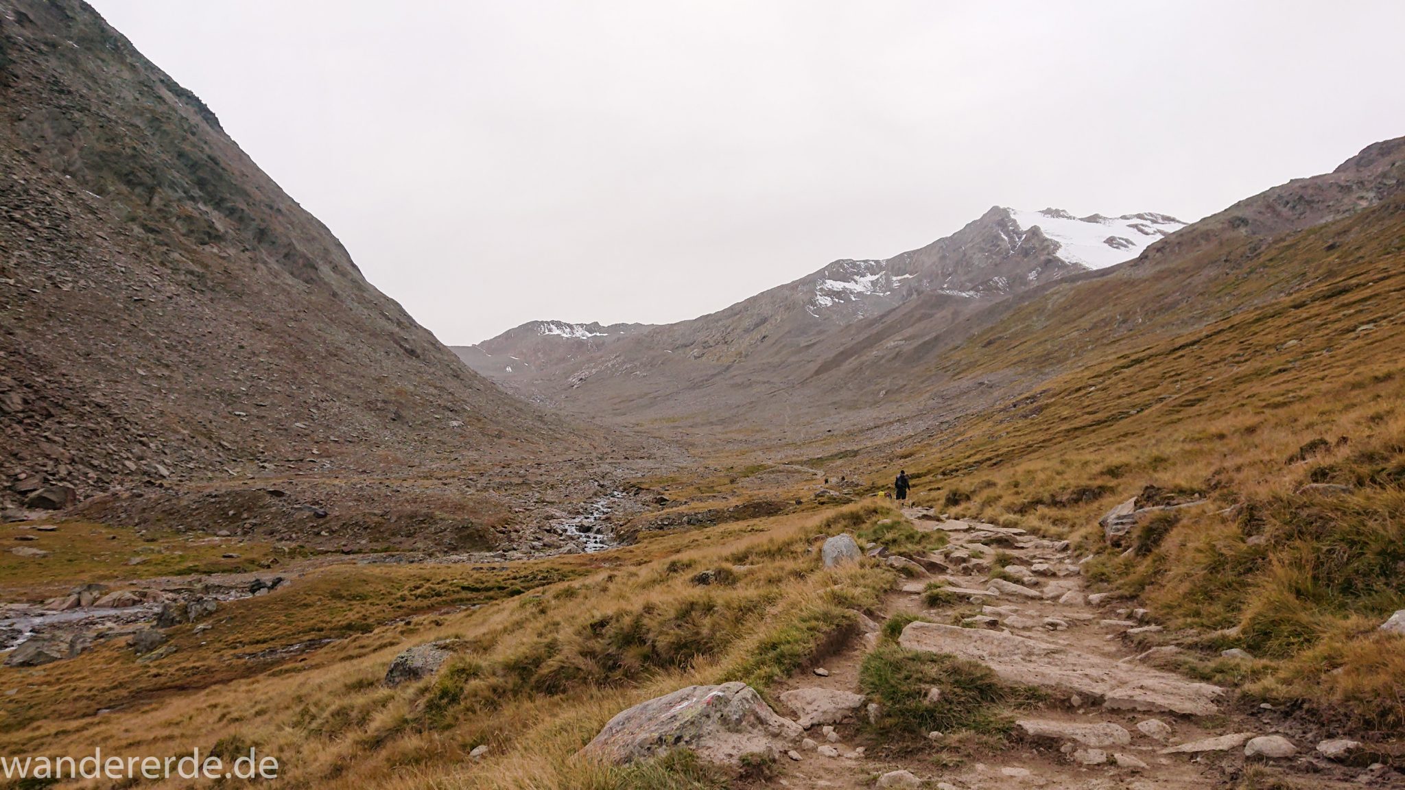 Alpenüberquerung Fernwanderweg E5 Oberstdorf Meran, 6. Etappe von Martin-Busch-Hütte nach Vernagt / Meran, die letzte Etappe der Alpenüberquerung auf dem E5 startet mit dem Aufstieg zur Similaun-Hütte, dem höchsten Punkt der gesamten Alpenüberquerung, umliegende sehr beeindruckende Bergwelt erscheint unwirklich und mystisch, Berghänge mit viel Geröll, grob steiniger Wanderweg verläuft zunächst gering ansteigend neben einem Bach