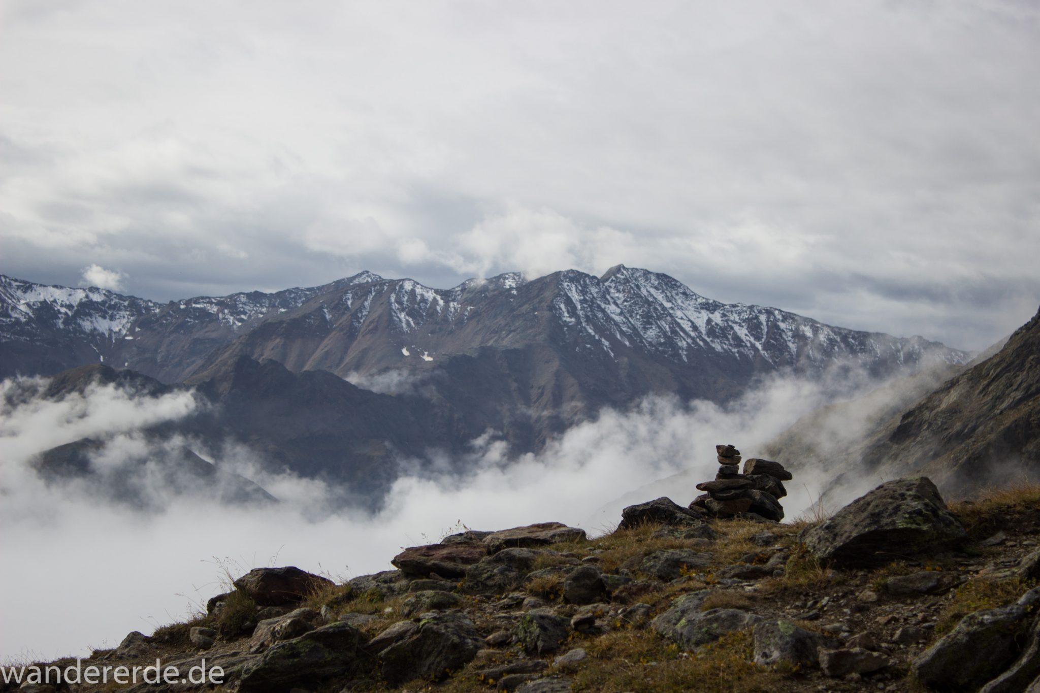 Alpenüberquerung Fernwanderweg E5 Oberstdorf Meran, 6. Etappe von Martin-Busch-Hütte nach Vernagt / Meran, nach dem Aufstieg zur Similaun-Hütte auf der letzten Etappe der Alpenüberquerung auf dem E5 verläuft der Wanderweg steil abwärts Richtung Vernagt im Schnalstal,  Blick auf Bergmassiv während Abstieg, erscheint unwirklich und mystisch, Wanderung mit steilem Abstieg auf ausgesetztem Pfad