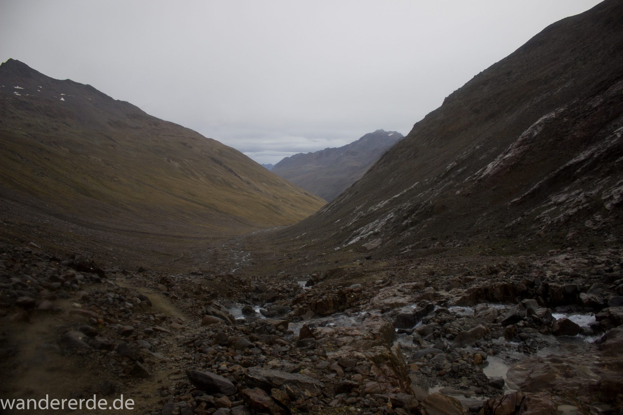 Alpenüberquerung Fernwanderweg E5 Oberstdorf Meran, 6. Etappe von Martin-Busch-Hütte nach Vernagt / Meran, die letzte Etappe der Alpenüberquerung auf dem E5 startet mit dem Aufstieg zur Similaun-Hütte, dem höchsten Punkt der gesamten Alpenüberquerung, umliegende sehr beeindruckende Bergwelt erscheint unwirklich und mystisch, Berghänge mit viel Geröll, grob steiniger Wanderweg verläuft zunächst gering ansteigend neben einem Bach