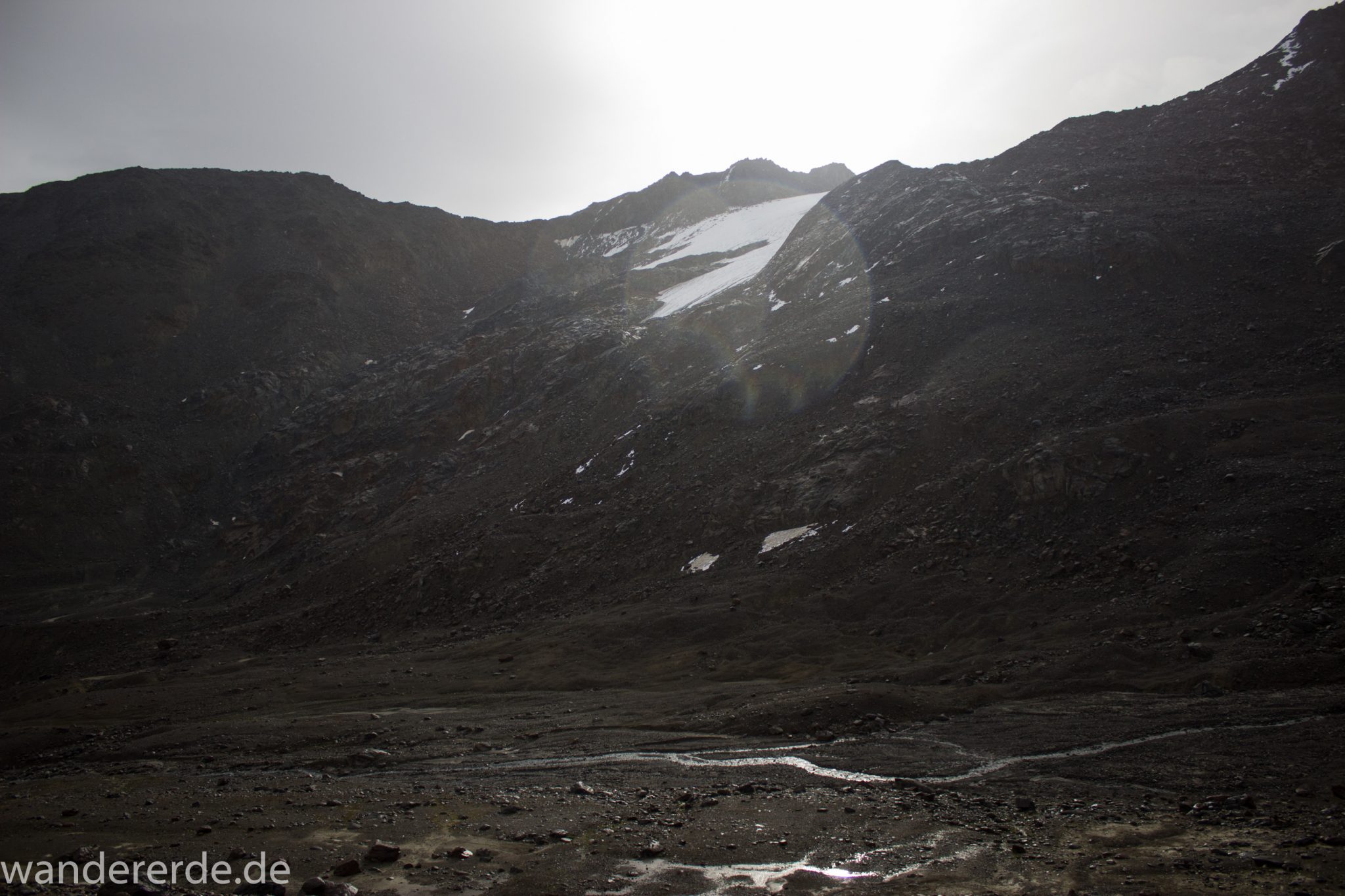 Alpenüberquerung Fernwanderweg E5 Oberstdorf Meran, 6. Etappe von Martin-Busch-Hütte nach Vernagt / Meran, die letzte Etappe der Alpenüberquerung auf dem E5 startet mit dem Aufstieg zur Similaun-Hütte, dem höchsten Punkt der gesamten Alpenüberquerung, umliegende sehr beeindruckende Bergwelt erscheint unwirklich und mystisch, Berghänge mit viel Geröll, grob steiniger Wanderweg verläuft zunächst gering ansteigend neben einem Bach