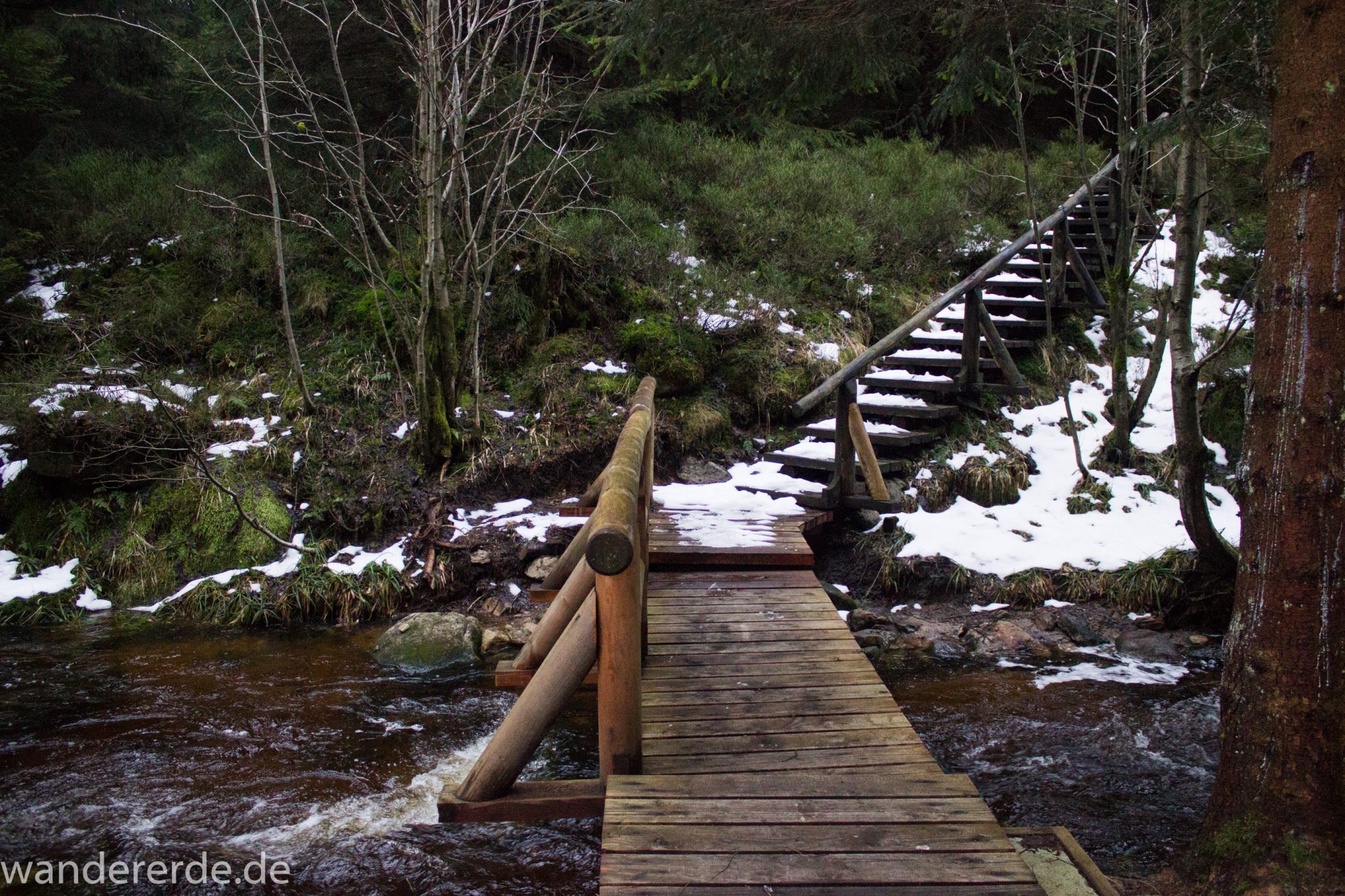 Wanderung zum Brocken über Goetheweg ab Torfhaus, Wanderung im Harz in Niedersachsen, Wanderweg auf Berg Brocken in Sachsen-Anhalt, Reste von Schnee schmelzen, von Brocken zurück zum Torfhaus über den Wanderweg durch das Eckertal, Fluss Ecker fließt mal mehr und mal weniger über den schmalen Wanderweg, kleine Brücke zur Überquerung der Ecker, umgeben von schönem, dichtem Wald, im Winter bei Schneeschmelze also unbedingt wasserdichte Schuhe