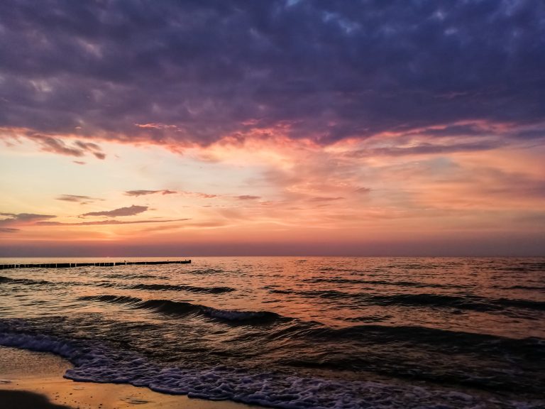 Wandern an der Ostsee von Ahrenshoop nach Zingst auf dem E9, siebte Etappe des Wanderwegs an der Ostseeküste von Wismar nach Zingst, Ziel der Wanderung an der Ostsee auf dem E9 erreicht, Ort Zingst auf der Halbinsel Fischland-Darß-Zingst, nach Gewitter traumhaftes Licht und Farben während des Sonnenuntergangs, Wellen brechen sanft am Ufer