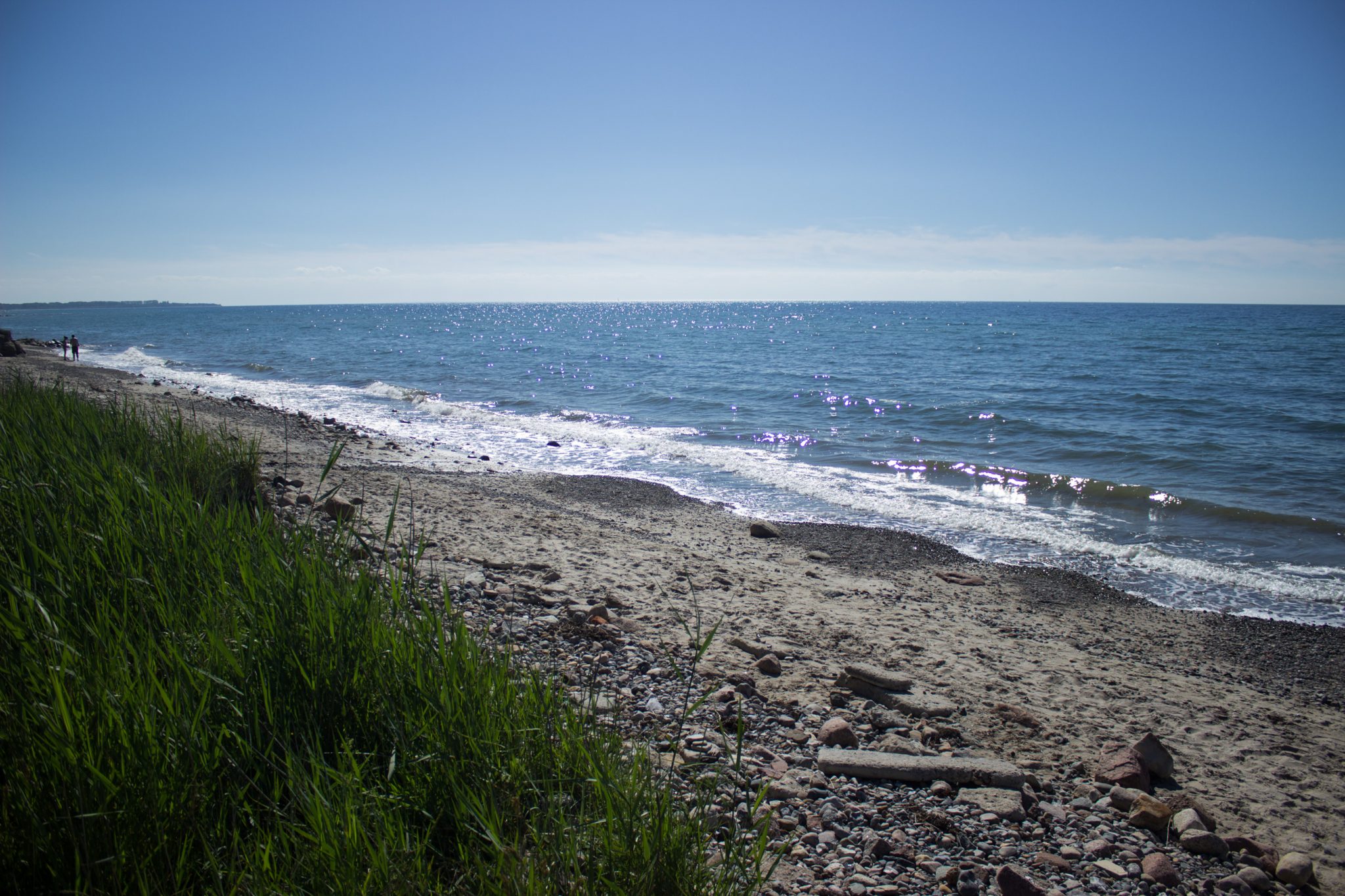 Wandern an der Ostsee vom Salzhaff nach Kühlungsborn auf dem E9 Fernwanderweg, zweite Etappe des Wanderwegs an der Ostseeküste von Wismar nach Zingst, Blick auf die schöne Ostsee im Sommer, fast menschenleerer Strand