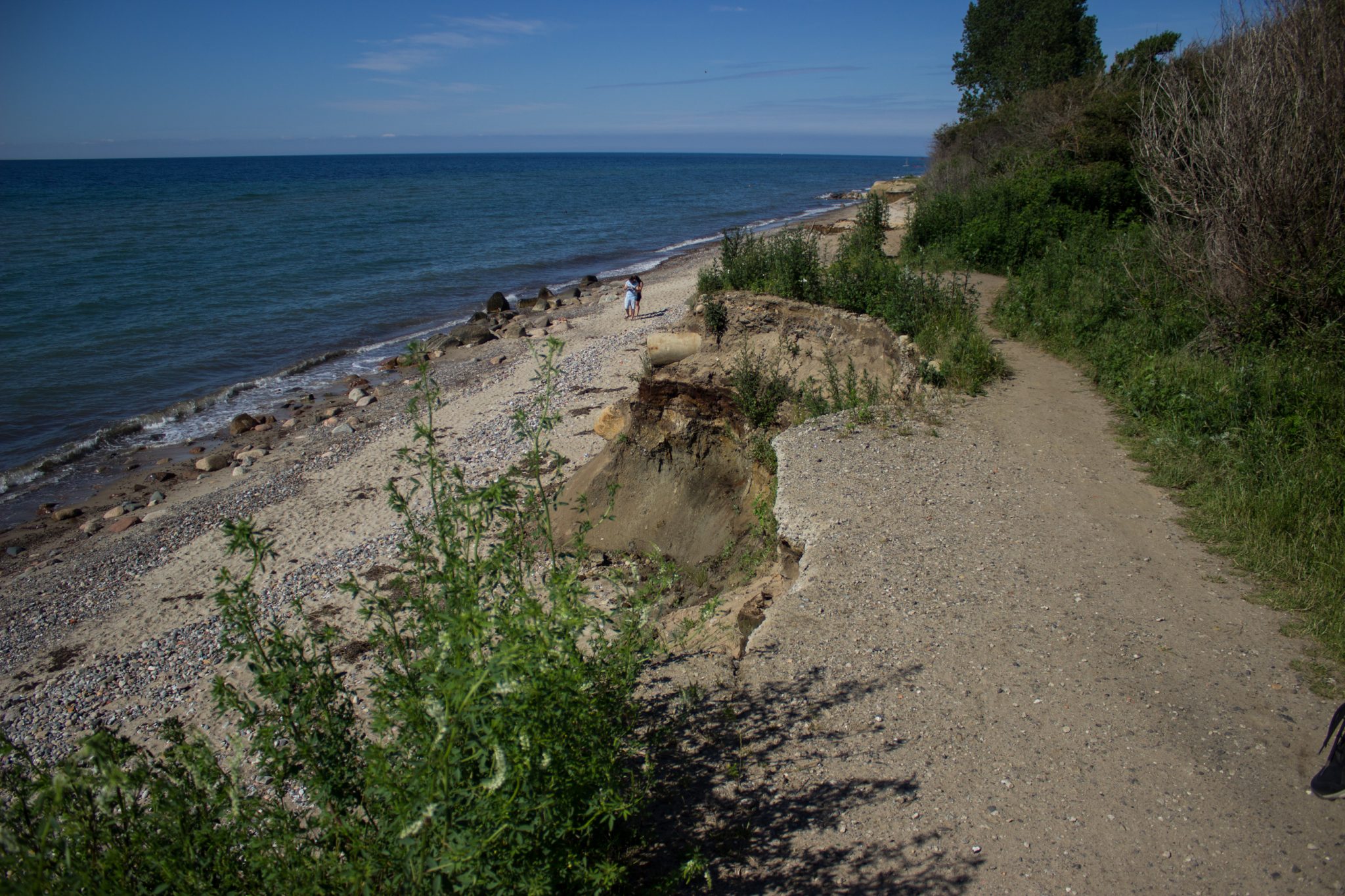 Wandern an der Ostsee vom Salzhaff nach Kühlungsborn auf dem E9 Fernwanderweg, zweite Etappe des Wanderwegs an der Ostseeküste von Wismar nach Zingst, abgebrochene Steilküste an der Ostsee, Weg fast nicht mehr vorhanden, fast menschenleerer Strand