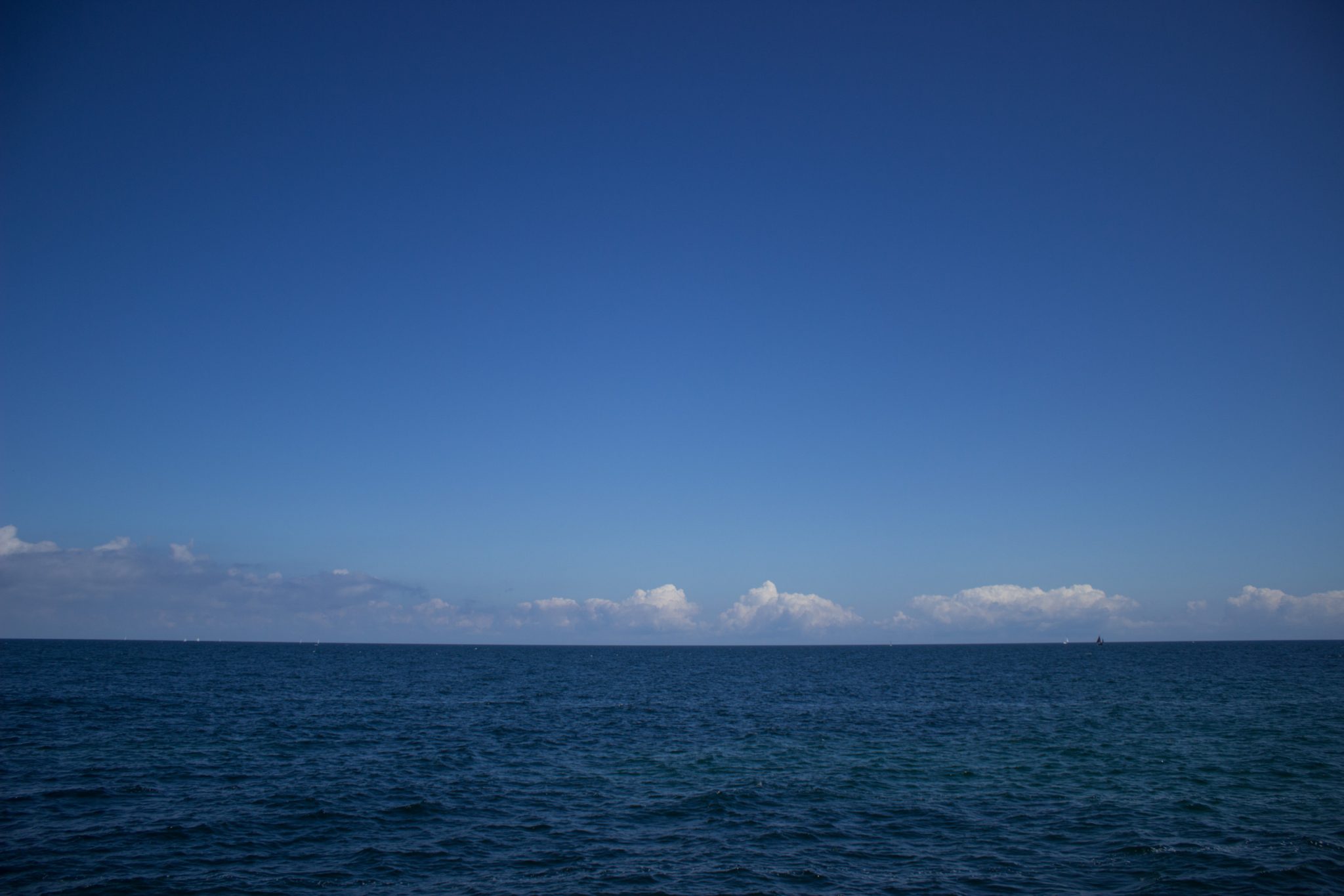 Wandern an der Ostsee von Kühlungsborn nach Börgerende auf dem E9, dritte Etappe des Wanderwegs an der Ostseeküste von Wismar nach Zingst, Blick von der Seebrücke in Kühlungsborn Richtung unendlicher Ostsee, schöne Aussicht strahlend blauer Himmel im Sommer