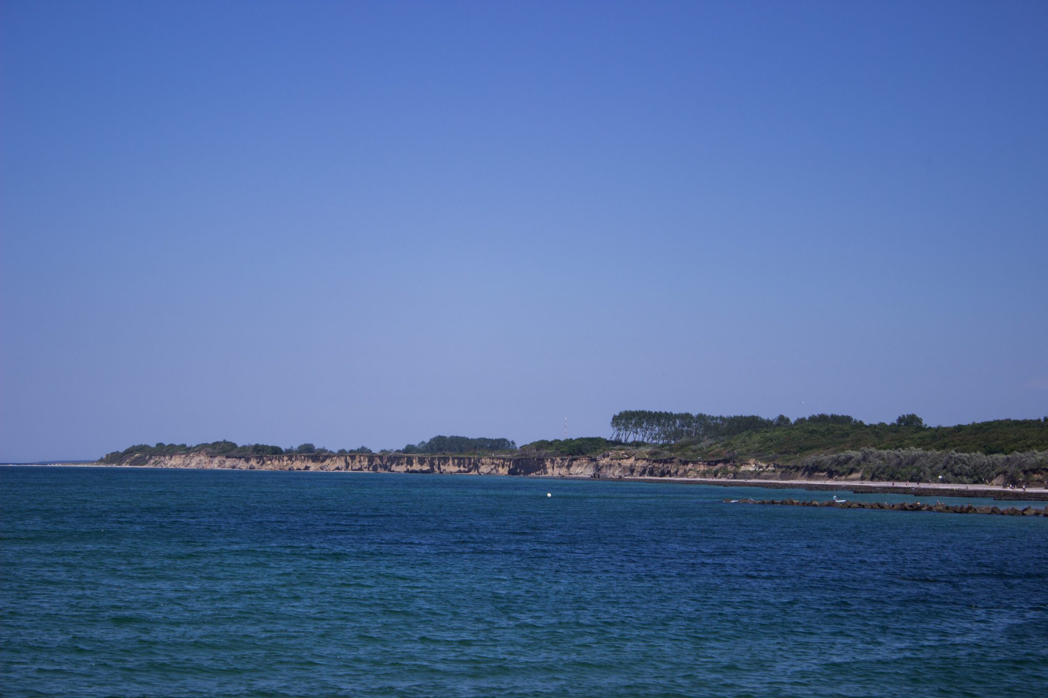 Wandern an der Ostsee von Dierhagen nach Ahrenshoop auf dem E9, sechste Etappe des Wanderwegs an der Ostseeküste von Wismar nach Zingst, am Strand an der Ostsee wandern wir weiter Richtung Ort Wustrow, traumhaft schöne Aussicht auf das Meer und die Steilküste, Ostsee mit sauberem klarem Wasser, wolkenloser Himmel und Sonnenschein im Sommer