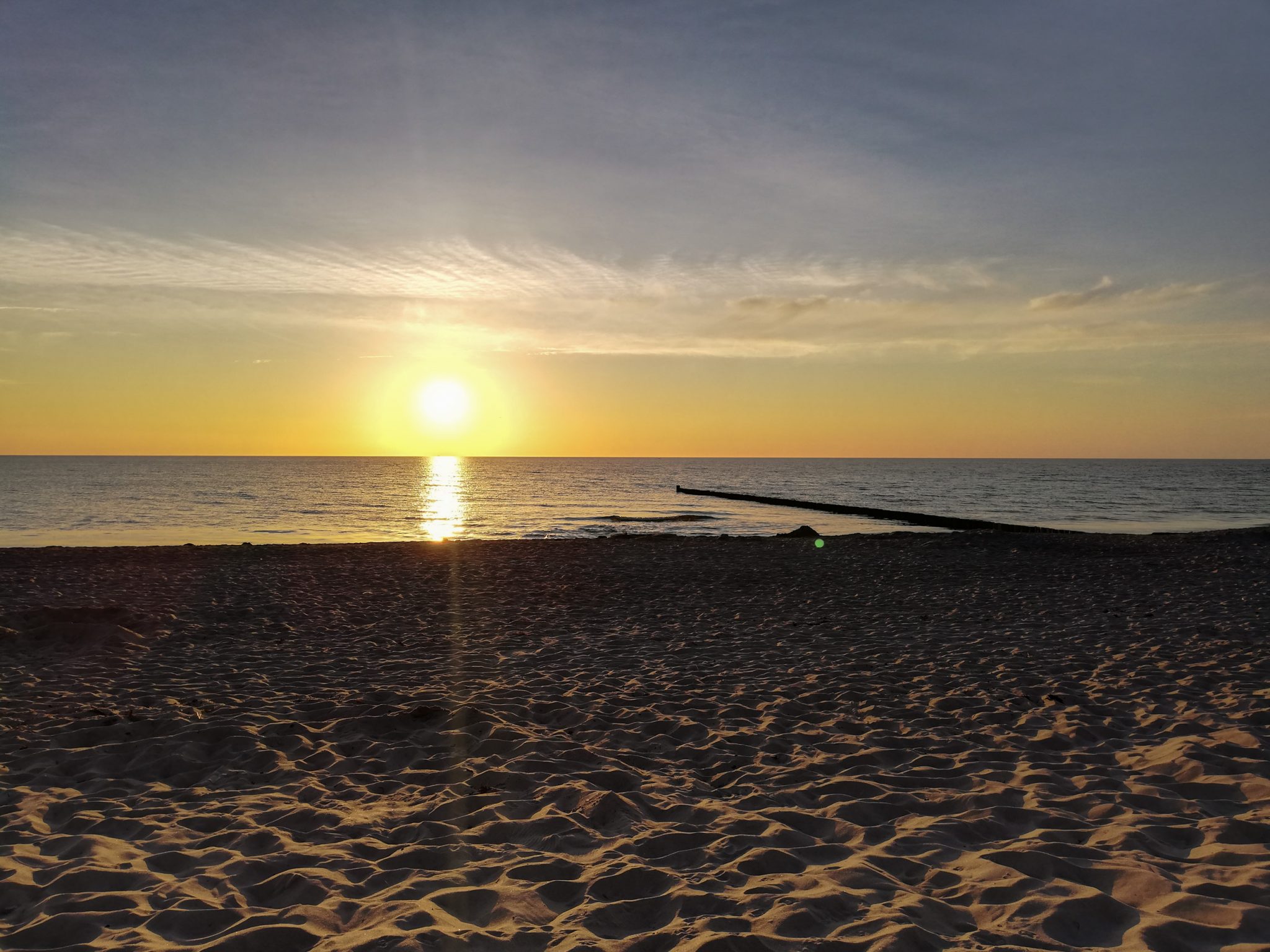 Wandern an der Ostsee von Markgrafenheide nach Dierhagen auf dem E9, fünfte Etappe des Wanderwegs an der Ostseeküste von Wismar nach Zingst, nach Erreichen des Etappenziels Dierhagen schöner Sonnenuntergang hinter dem Meer, Sonnenuntergänge an der Ostsee sind einmalig