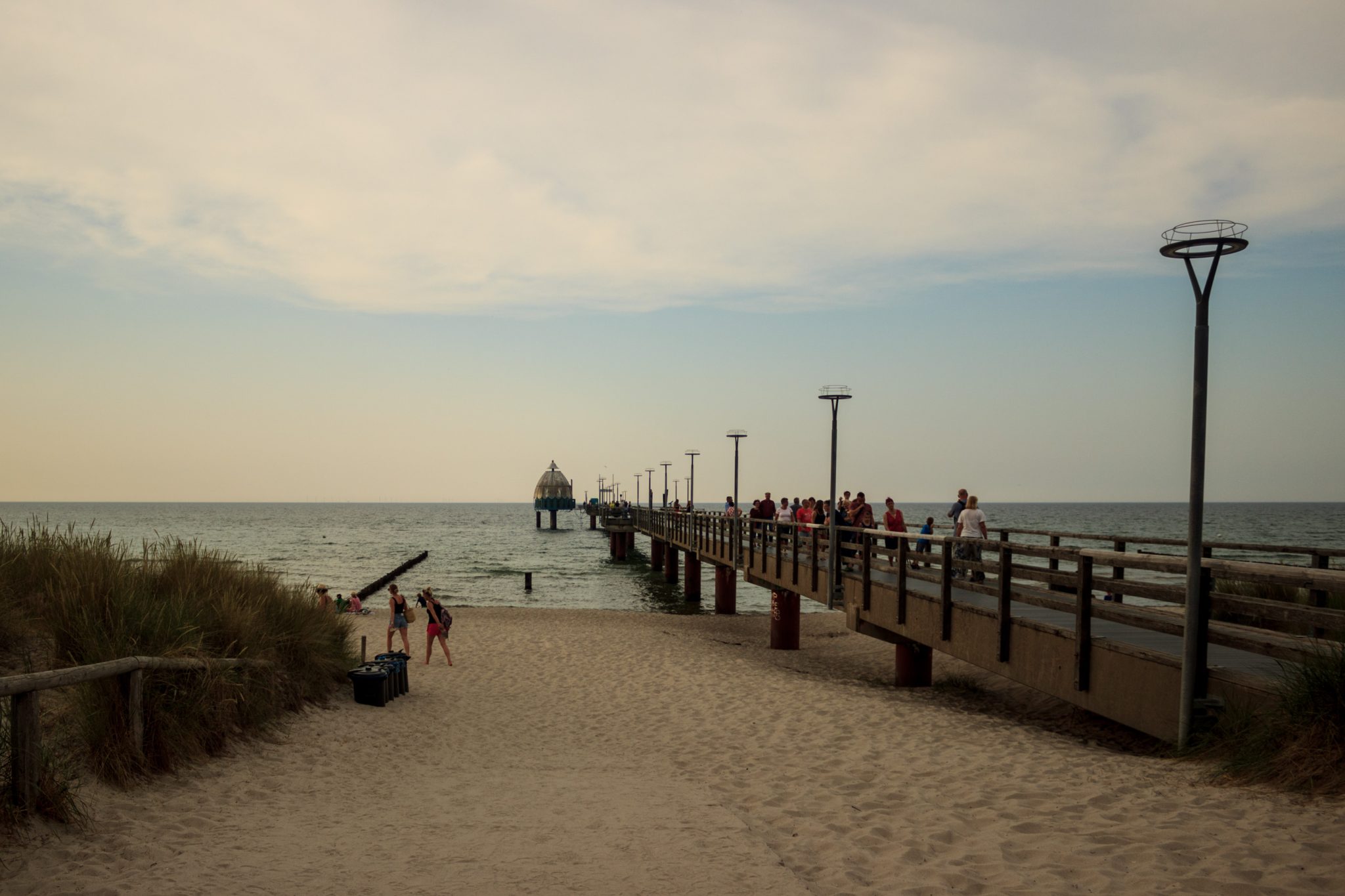 Wandern an der Ostsee von Ahrenshoop nach Zingst auf dem E9, siebte Etappe des Wanderwegs an der Ostseeküste von Wismar nach Zingst, Ziel der Wanderung Ort Zingst auf der Halbinsel Fischland-Darß-Zingst erreicht, Blick auf die Seebücke mit Tauchgondel, schöner Sandstrand, viele Urlauber auf der Seebrücke