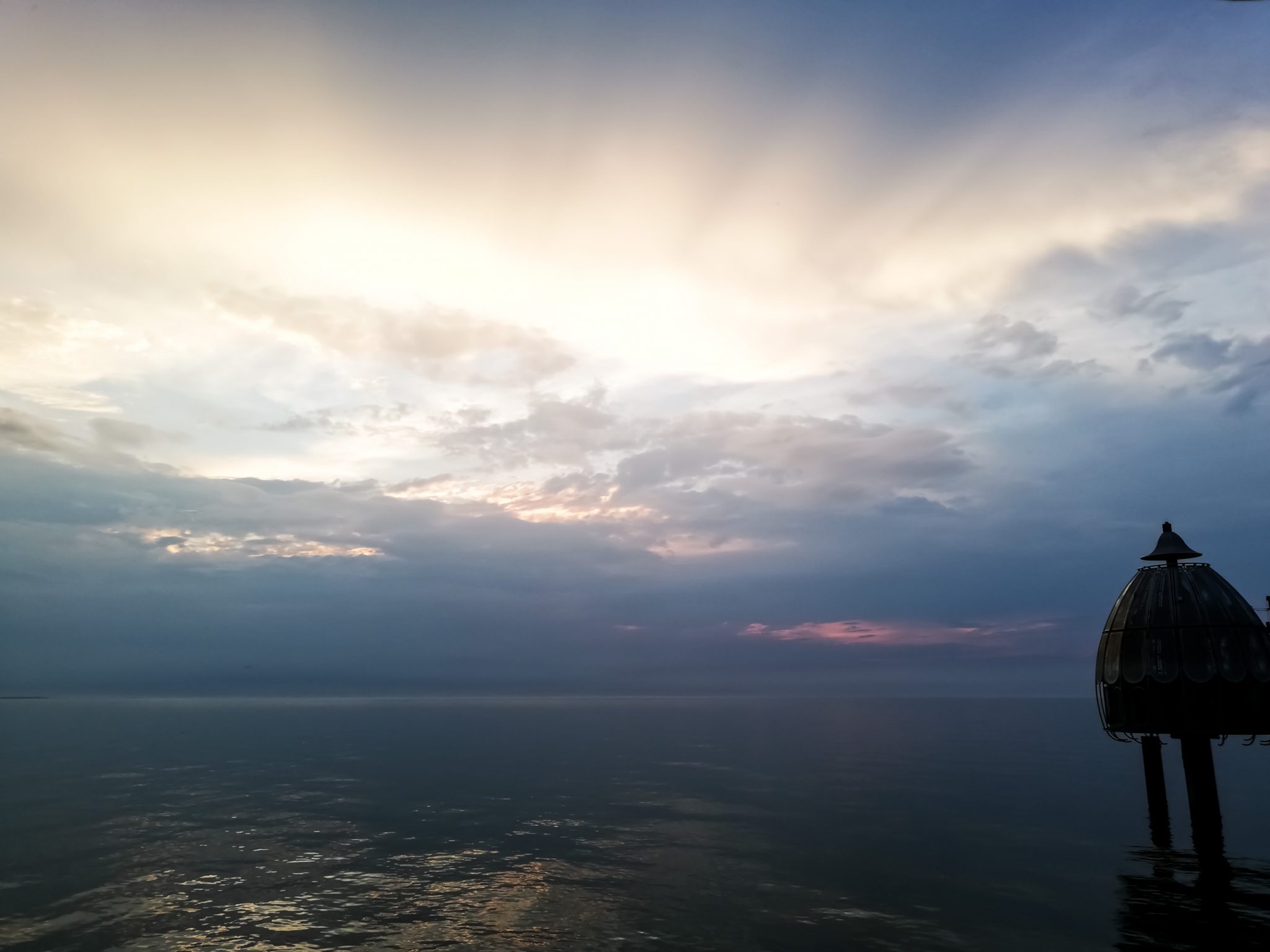 Wandern an der Ostsee von Ahrenshoop nach Zingst auf dem E9, siebte Etappe des Wanderwegs an der Ostseeküste von Wismar nach Zingst, Ziel der Wanderung an der Ostsee auf dem E9 erreicht, Ort Zingst auf der Halbinsel Fischland-Darß-Zingst, nach Gewitter traumhaftes Licht und Farben während des Sonnenuntergangs, Blick von der Seebrücke auf die Tauchgondel in Zingst, Ostsee ist ganz still, wunderschöne Lichtstimmung