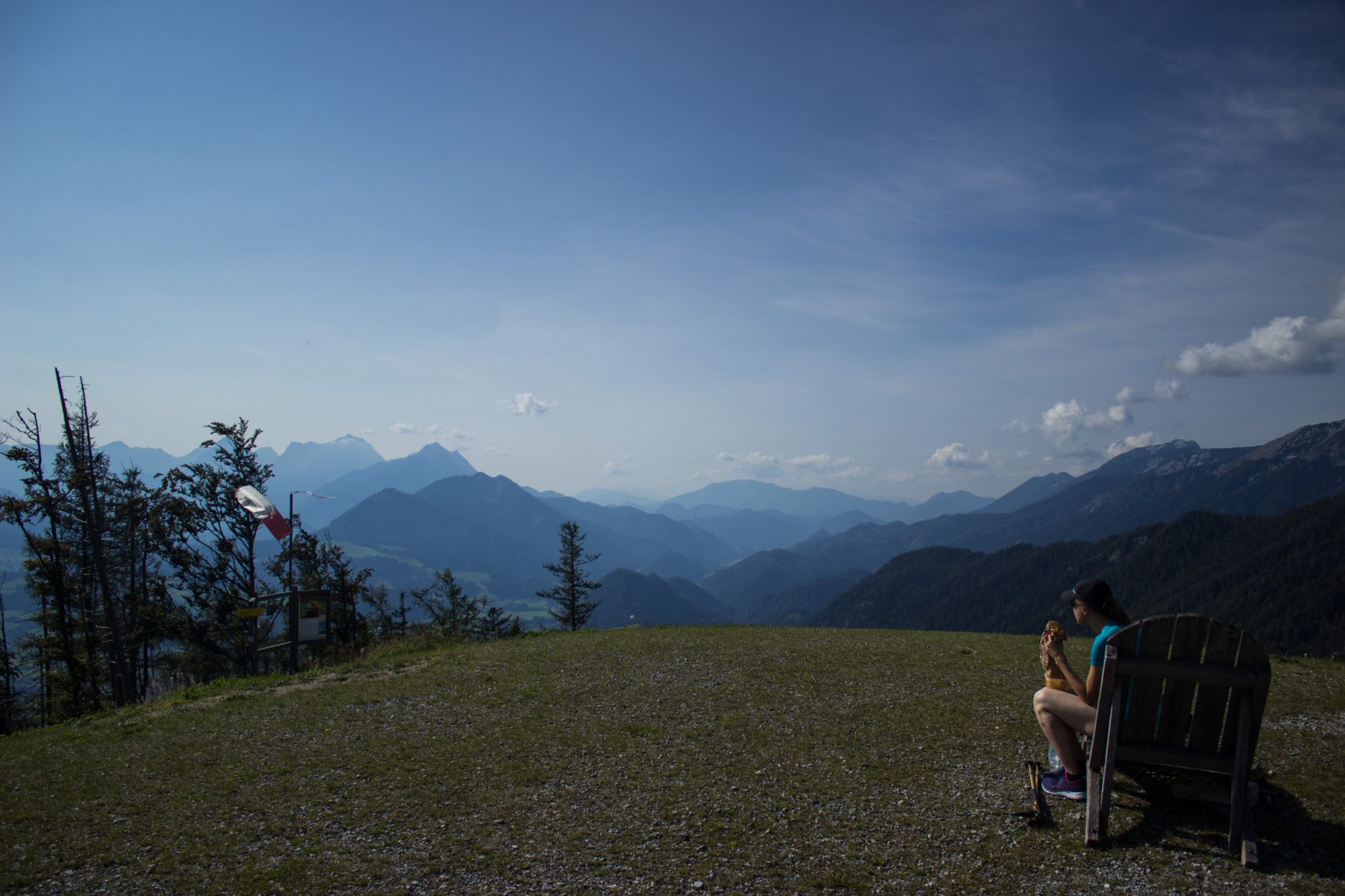 Wandern bei Windischgarsten auf den Kleinerberg über Salzabachtal, Leitersteig, Speikkogel und Schafsteig im Nationalpark Kalkalpen in Oberösterreich, Aussicht vom Kleinerberg auf das weite Tal, die umliegenden Berge und Wälder an warmem Sommertag, Wanderer genießt Aussicht, ausgiebige Pause auf Holzliege bietet sich an