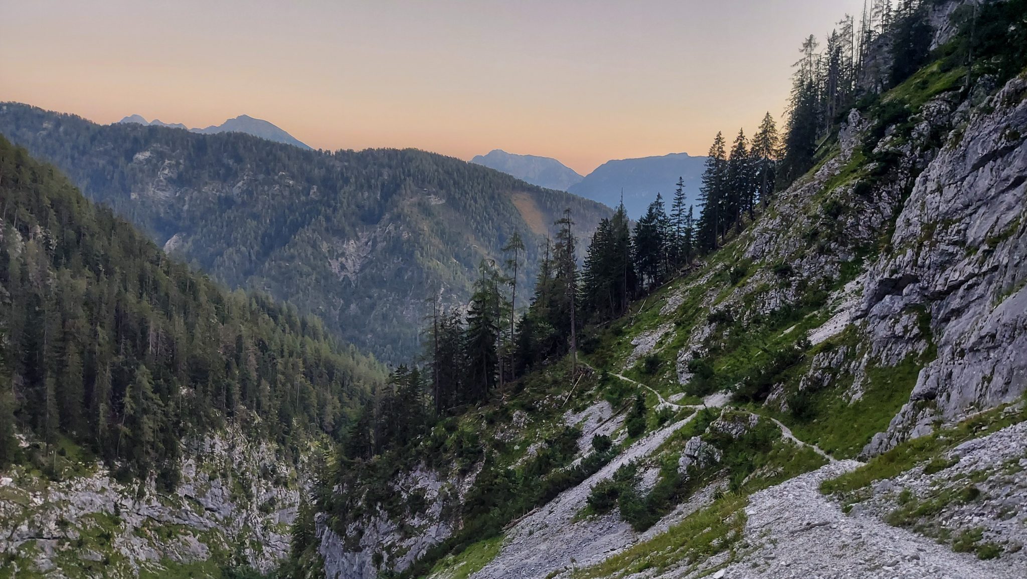 Wanderung Hoher Nock ab Windischgarsten im Nationalpark Kalkalpen in Oberösterreich, nahender Sonnenuntergang taucht die Berge in schönes Licht, auf dem Rückweg vom Berg Hoher Nock in Österreich, Aussicht auf Bäume und dahinterliegende Bergwelt, naturbelassener, sehr abwechslungsreicher Wanderweg führt über Geröllfelder am Berghang, Trittsicherheit und Schwindelfreiheit sind empfehlenswert