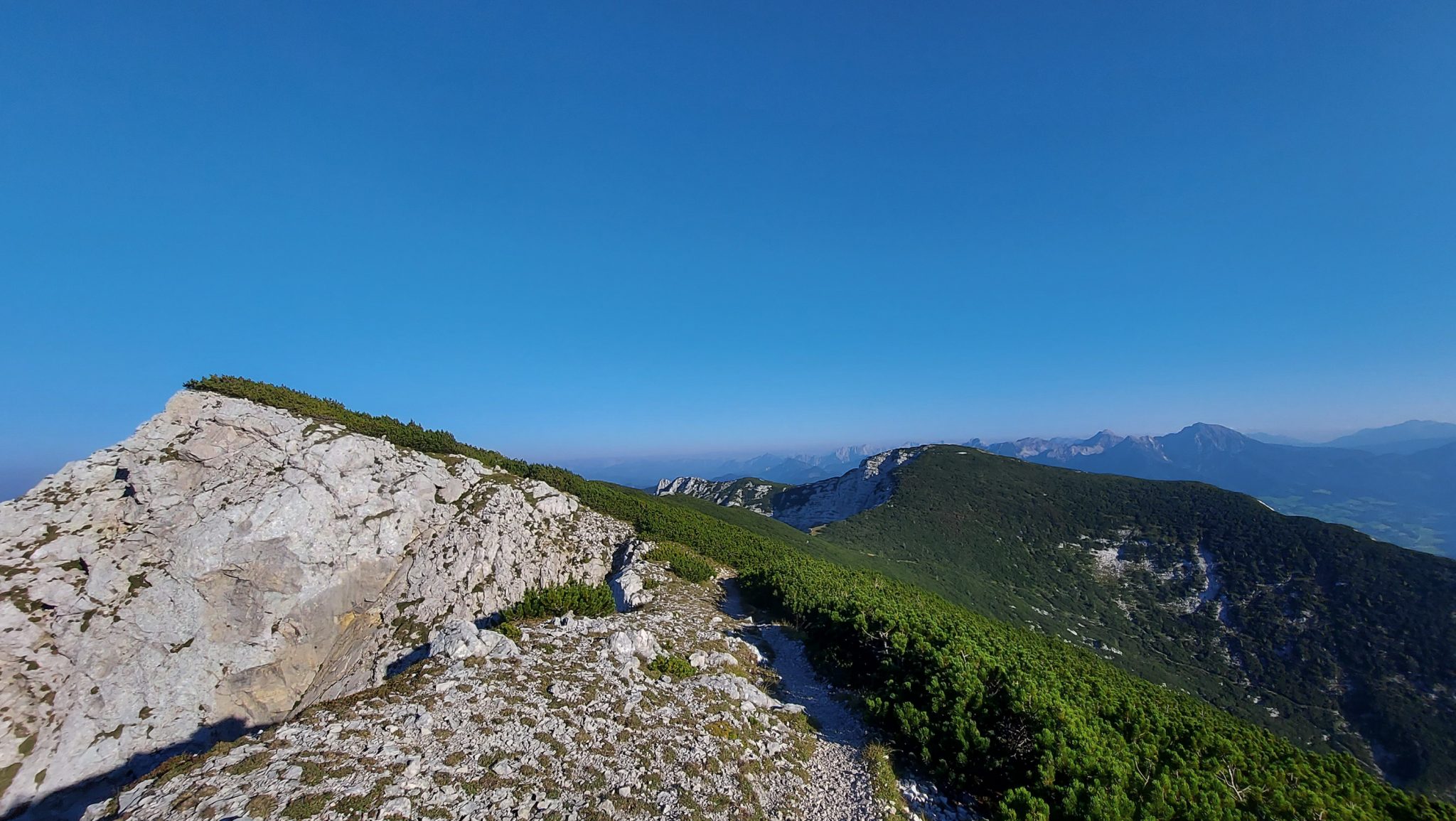 Wanderung Hoher Nock ab Windischgarsten im Nationalpark Kalkalpen in Oberösterreich, auf dem Rückweg vom Berg Hoher Nock in Österreich, schmaler Wanderweg über Stock und Stein, Trittsicherheit und Schwindelfreiheit ist empfehlenswert da Wegverlauf am Berghang, weite Aussicht auf umliegende Bergwelt, noch karge Vegetation während sehr abwechslungsreicher Wanderung