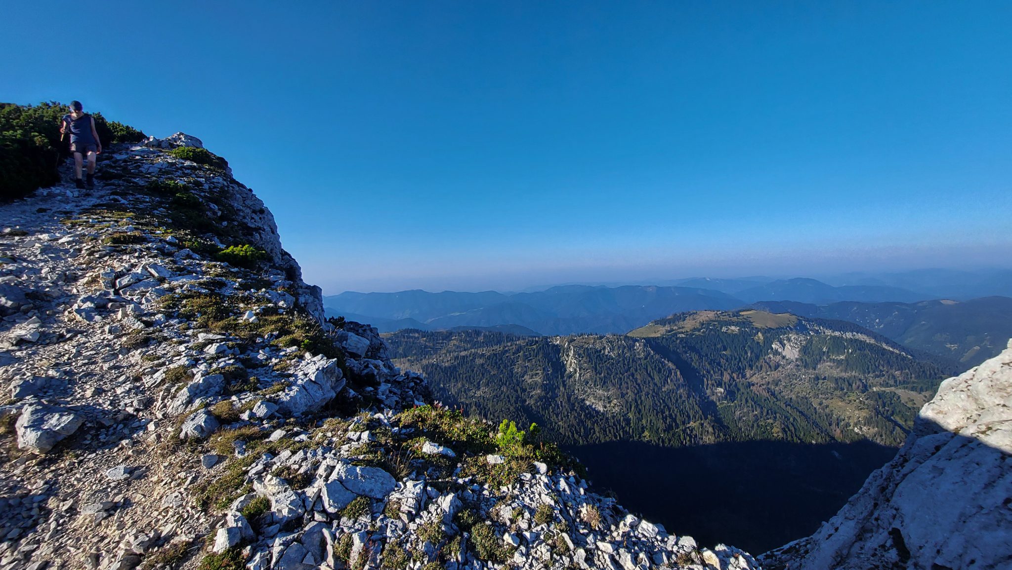Wanderung Hoher Nock ab Windischgarsten im Nationalpark Kalkalpen in Oberösterreich, auf dem Rückweg vom Berg Hoher Nock in Österreich, Wanderer unterwegs auf schmalem Wanderweg über Stock und Stein, Trittsicherheit und Schwindelfreiheit ist empfehlenswert da Wegverlauf am Berghang, weite Aussicht auf umliegende Bergwelt, karge Vegetation, sehr abwechslungsreiche Wanderung