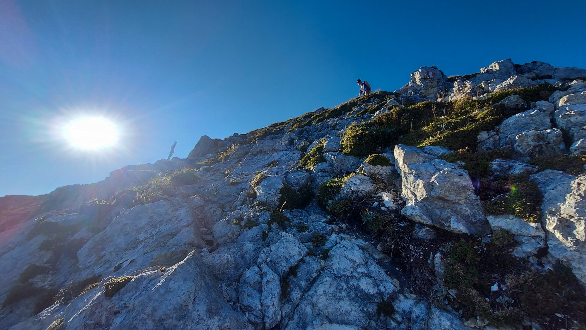 Wanderung Hoher Nock ab Windischgarsten im Nationalpark Kalkalpen in Oberösterreich, auf dem Berggipfel des Hohen Nocks angekommen, letzter Abschnitt der Wanderung ist sehr steil und führt über große Felsen, erfordert Schwindelfreiheit, Wanderer befindet sich auf großem Plateau auf dem Gipfel vom Berg Hoher Nock