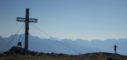 Wanderung Hoher Nock ab Windischgarsten im Nationalpark Kalkalpen in Oberösterreich, auf dem Berggipfel des Hohen Nocks mit Gipfelkreuz angekommen, großes Plateau auf dem Gipfel, tolle weite Aussichten auf die umliegenden Berge der Kalkalpen in Österreich, Wanderer genießt die Aussicht in alle Richtungen