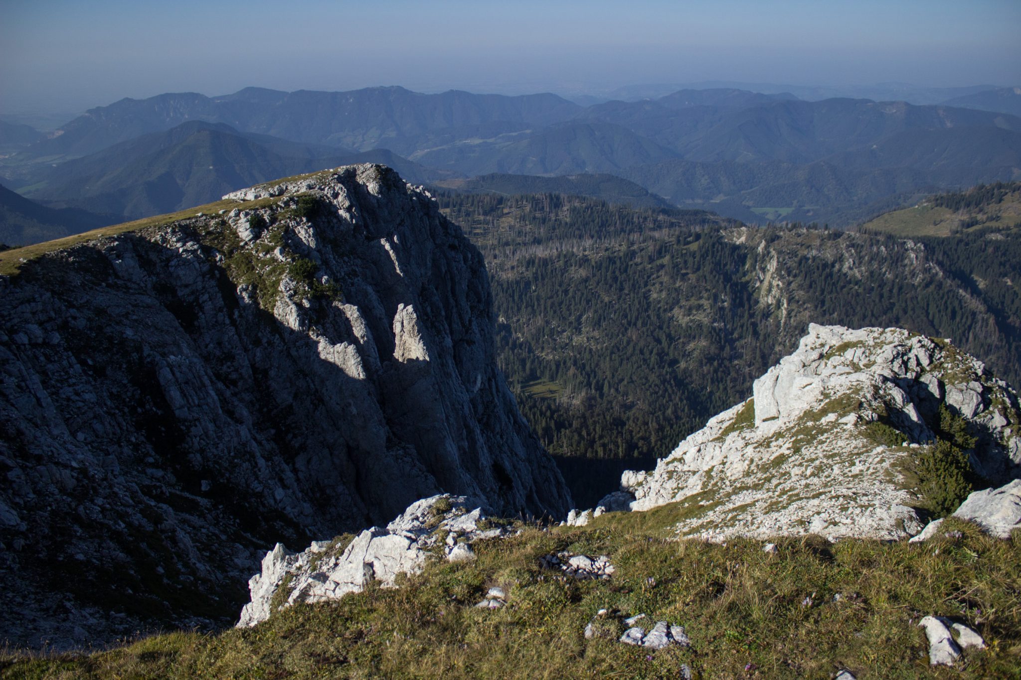 Wanderung Hoher Nock ab Windischgarsten im Nationalpark Kalkalpen in Oberösterreich, auf dem Berggipfel vom Hohen Nock angekommen mit ziemlich großer Gipfelebene, beeindruckender Blick auf die steil abfallenden Felswände vom Berg Hoher Nock, weite Aussichten auf die umliegende Bergwelt