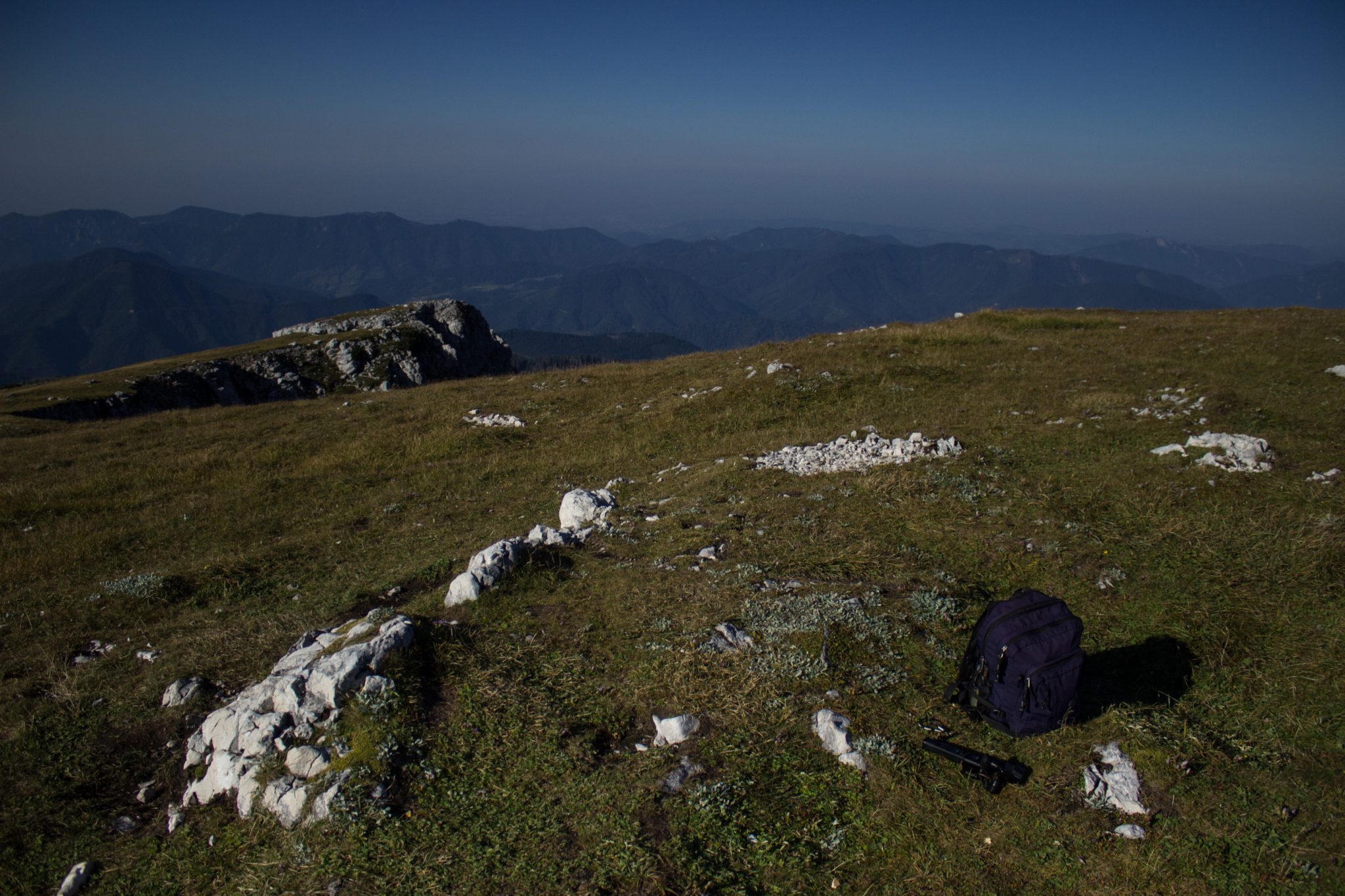 Wanderung Hoher Nock ab Windischgarsten im Nationalpark Kalkalpen in Oberösterreich, auf dem Berggipfel vom Hohen Nock angekommen mit ziemlich großer Gipfelebene, tolle weite Aussichten auf die umliegenden Berge der Kalkalpen in Österreich, Rucksack eines Wanderers