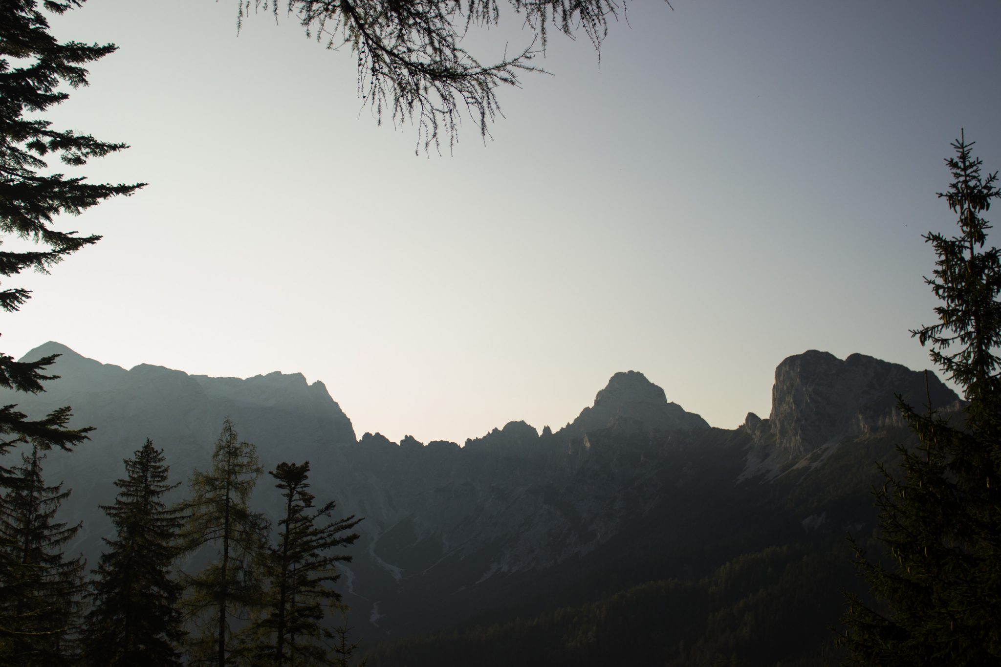 Wandern zur Ennstaler Hütte im Nationalpark Gesäuse im Bundesland Steiermark in Österreich, Wanderweg in den Ennstaler Alpen ab Parkplatz Gstatterboden, Blick auf dichten Wald und die imposanten Berge im Gesäuse, sehr beeindruckende Aussicht auf mehrere Gebirgszüge hintereinander, warmer Tag im Spätsommer