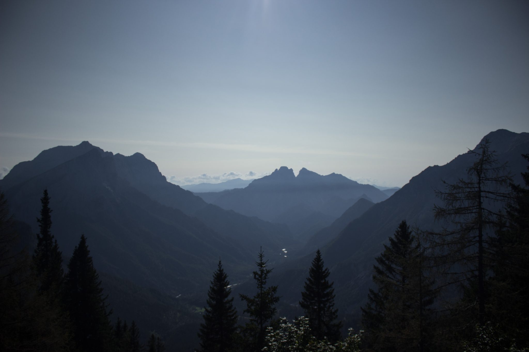 Wandern zur Ennstaler Hütte im Nationalpark Gesäuse im Bundesland Steiermark in Österreich, Wanderweg in den Ennstaler Alpen ab Parkplatz Gstatterboden, Blick auf dichten Wald und die imposanten Berge im Gesäuse, sehr beeindruckende Aussicht auf mehrere Gebirgszüge hintereinander, warmer Tag im Spätsommer