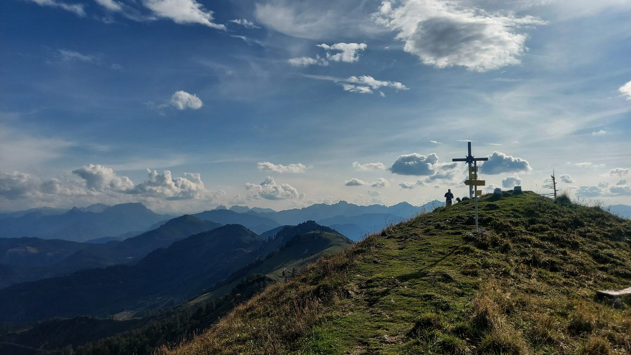 Wanderung zur Ennser Hütte und auf den Almkogel vom Parkplatz Bamacher bei  Großraming in Oberösterreich, Nationalpark-Region Ennstal, beim Almkogel gibt es eine weite und grandiose Aussicht auf die umliegende Bergwelt der Oberösterreichischen Voralpen, Wanderer genießt nach Erreichen des Gipfelkreuzes die Aussicht, herrlicher Wandertag im Sommer