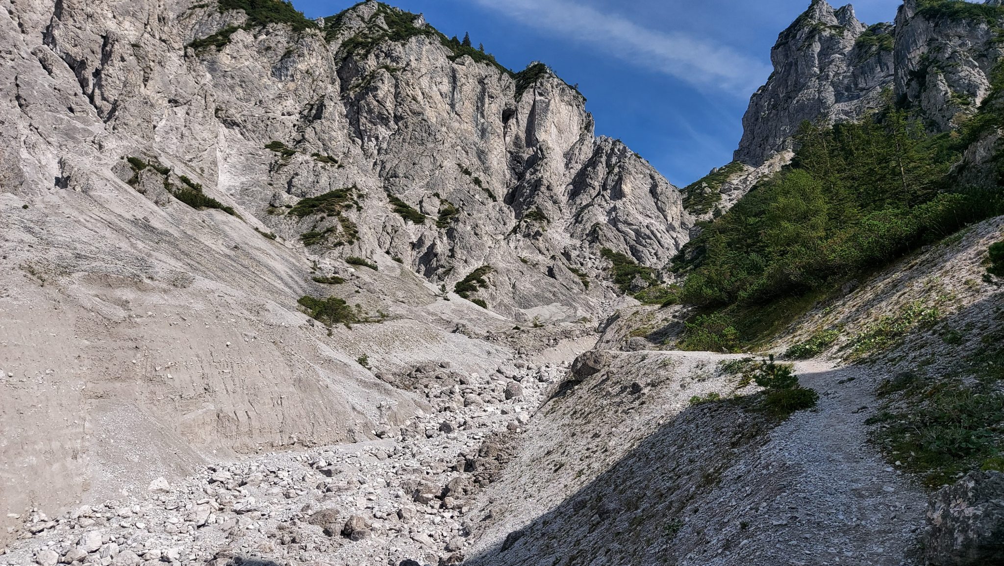 Wanderung zur Haindlkarhütte und Gsengscharte im Nationalpark Gesäuse im Bundesland Steiermark in Österreich, Wanderweg in den Ennstaler Alpen ab Parkplatz Haindlkarhütte vom Gstatterboden, Blick auf die beeindruckende Bergwelt im Gesäuse, nach dem Abstieg von der Gsengscharte ebnet sich der Weg zunehmend mit Erreichen des Tals, Berge türmen sich vor einem auf, große Geröllfelder im Tal