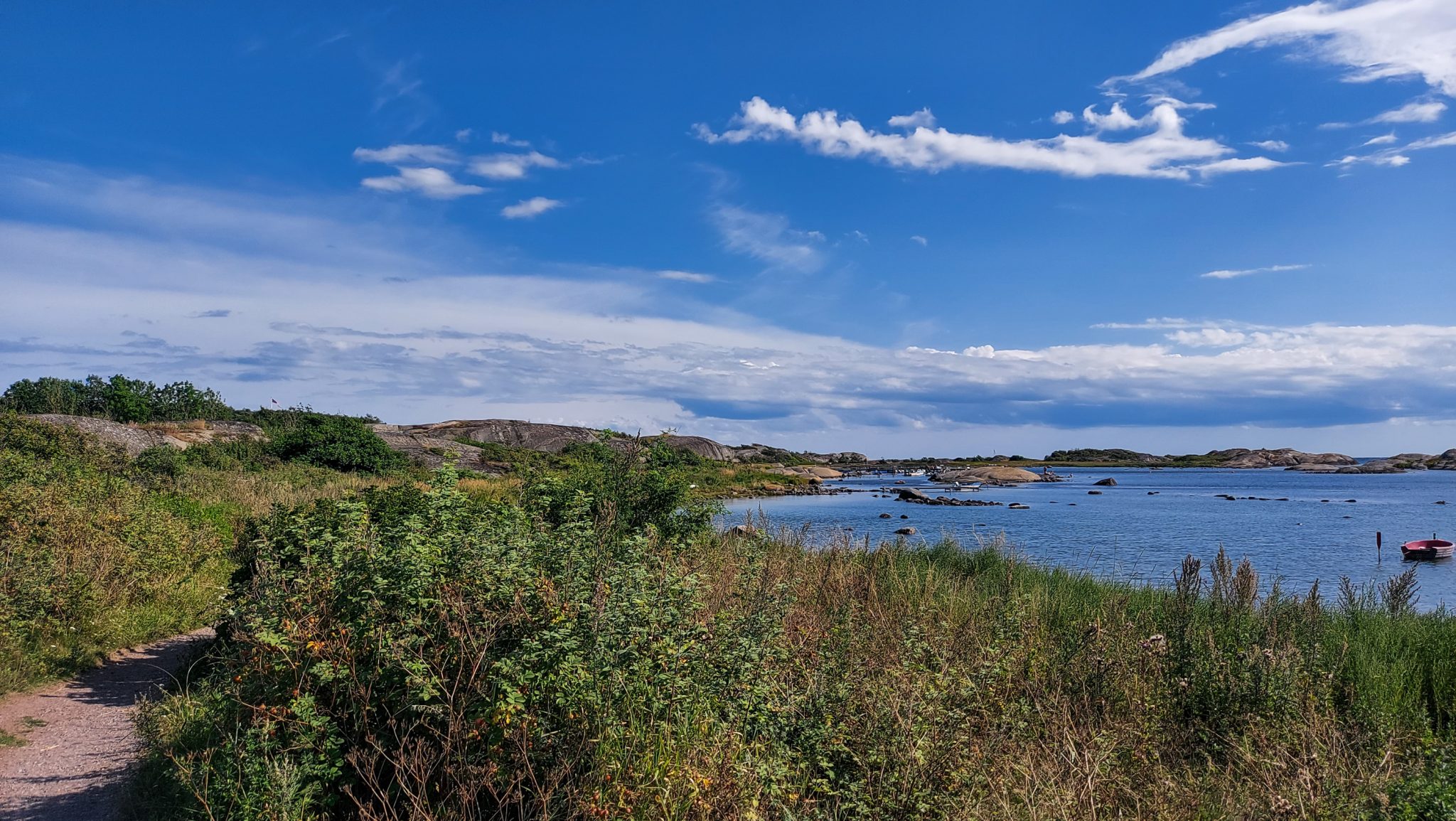 Küstenwanderung von Stavern nach Nevlunghavn, auf dem Kyststien entlang der Schärenküste von Vestfold in Südnorwegen, Wanderung entlang des Küstenpfads, Küstenvegetation entlang des Wanderweges, Meer und Felsen im Hintergrund, schönes Wetter zum Wandern