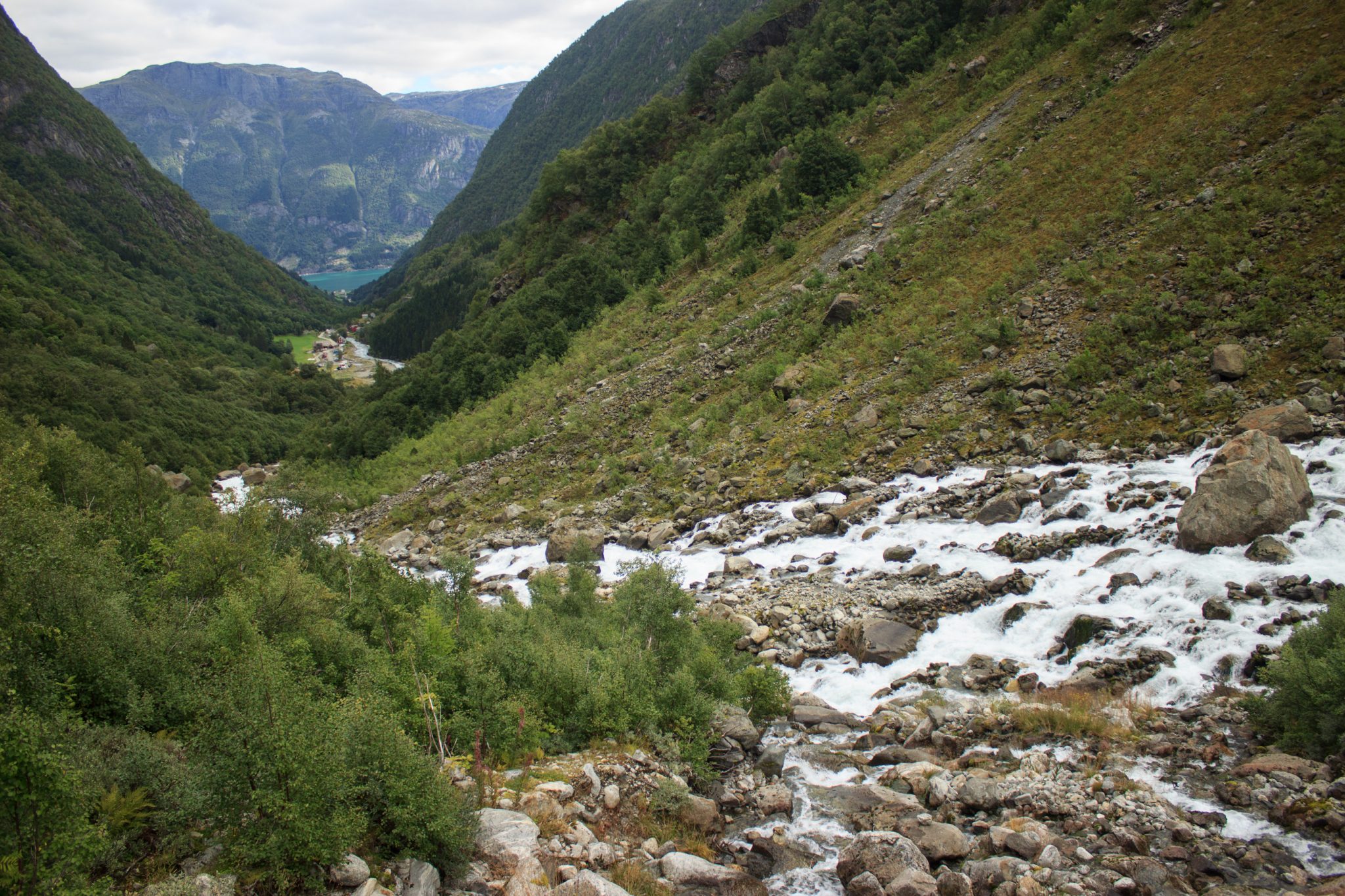 Wandern zum Buarbreen im Folgefonna Nationalpark, Wanderung in der Nähe von Odda mit Aussicht auf den Gletscher Buarbreen und Wasserfälle, Aussicht auf den strömenden Fluss und die Berge auf der gegenüberliegenden Seite vom Gletscher Bondusbreen