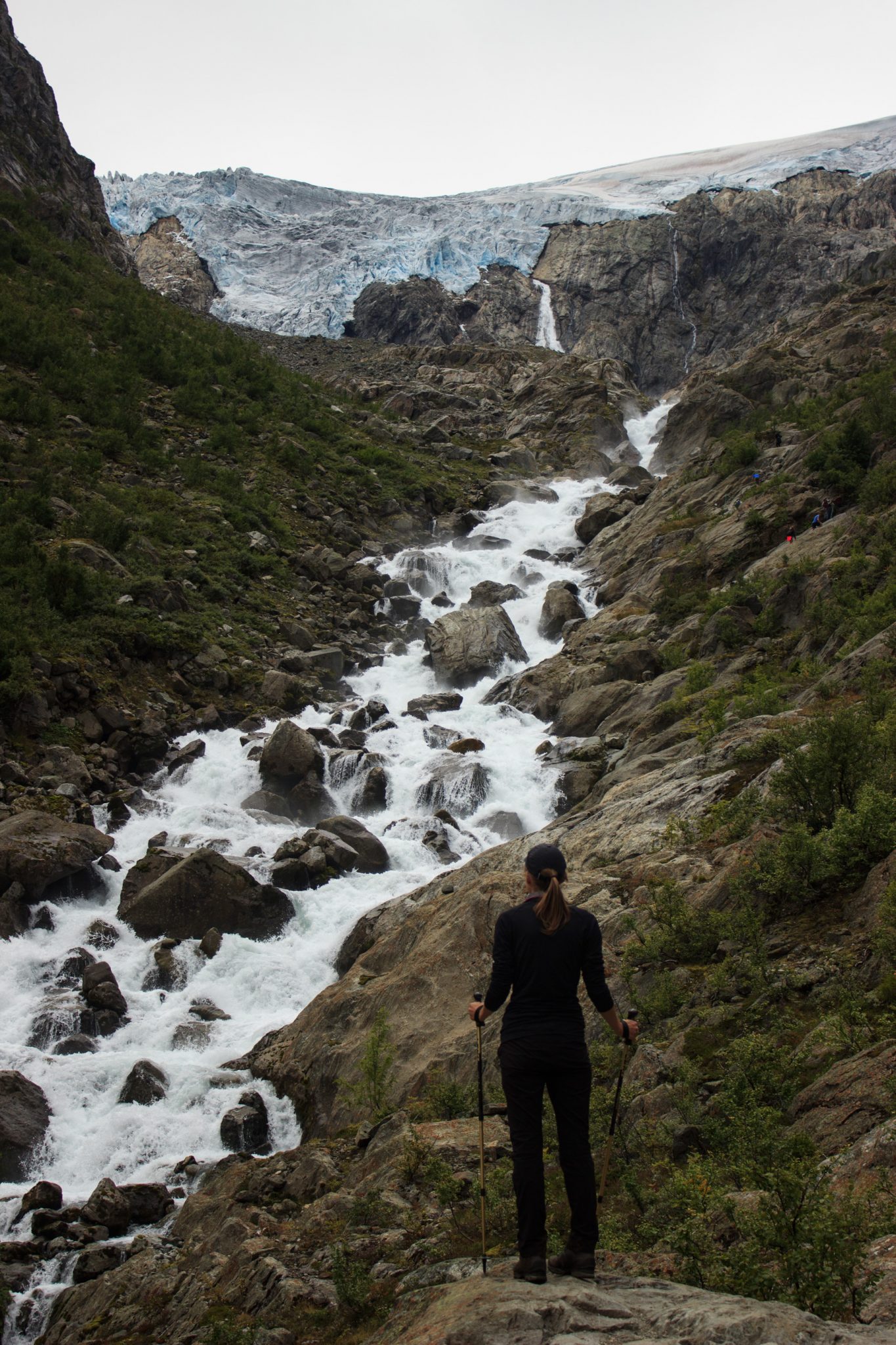 Wandern zum Buarbreen im Folgefonna Nationalpark, Wanderung in der Nähe von Odda mit Aussicht auf den Gletscher Buarbreen und Wasserfälle, Wanderer genießt Blick auf den Gletscher und den reißenden Fluss