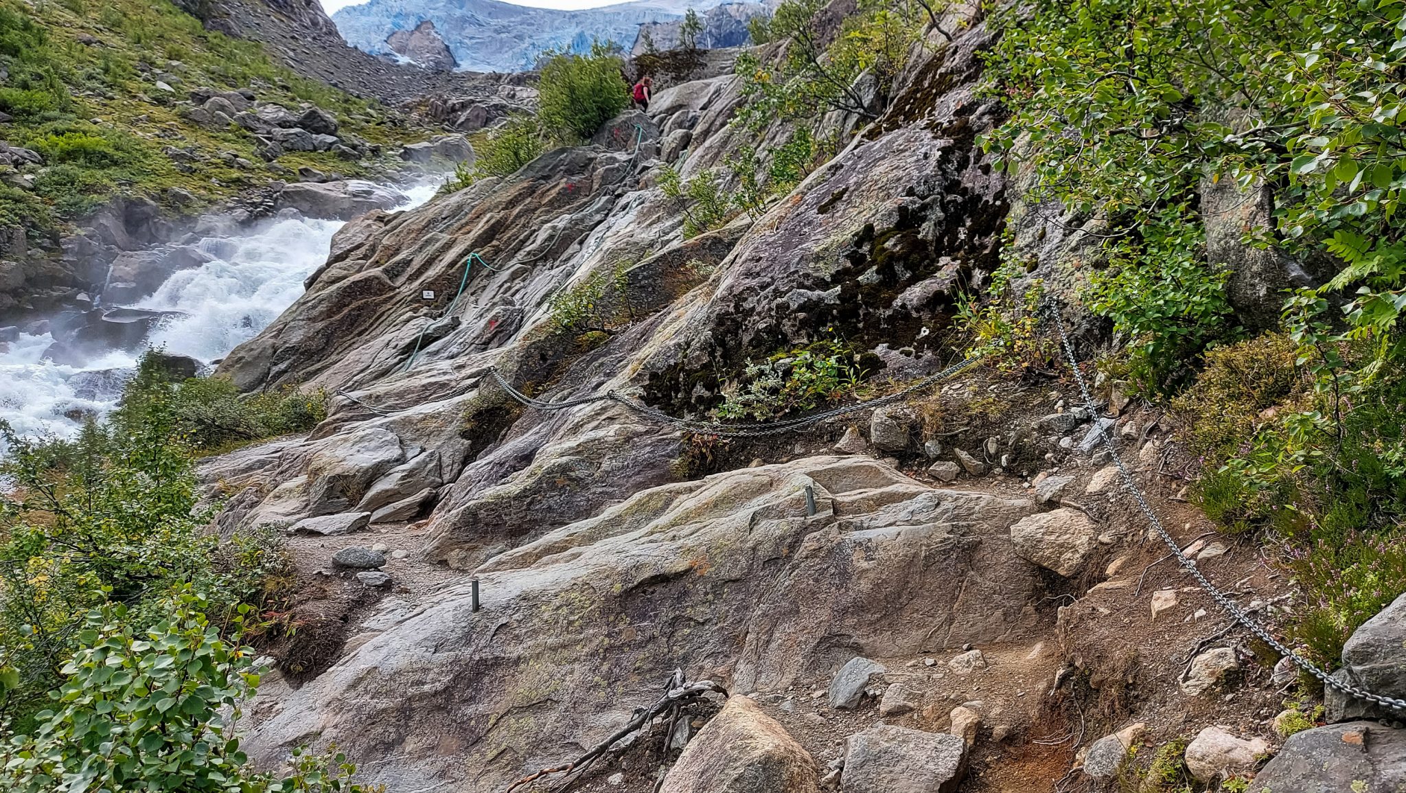 Wandern zum Buarbreen im Folgefonna Nationalpark, Wanderung in der Nähe von Odda mit Aussicht auf den Gletscher Buarbreen und Wasserfälle, Wanderer unterwegs auf teils steilem Wanderweg, teilweise gesichert mit Seilen