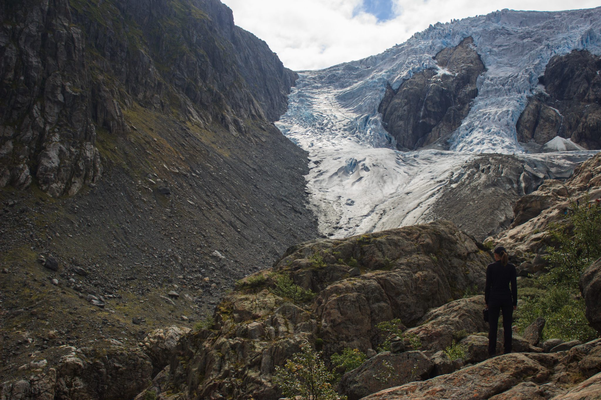 Wandern zum Buarbreen im Folgefonna Nationalpark, Wanderung in der Nähe von Odda mit Aussicht auf den Gletscher Buarbreen und Wasserfälle, Wanderer blickt auf den Gletscher und die umliegenden Berge während der Wanderung zum Buarbreen