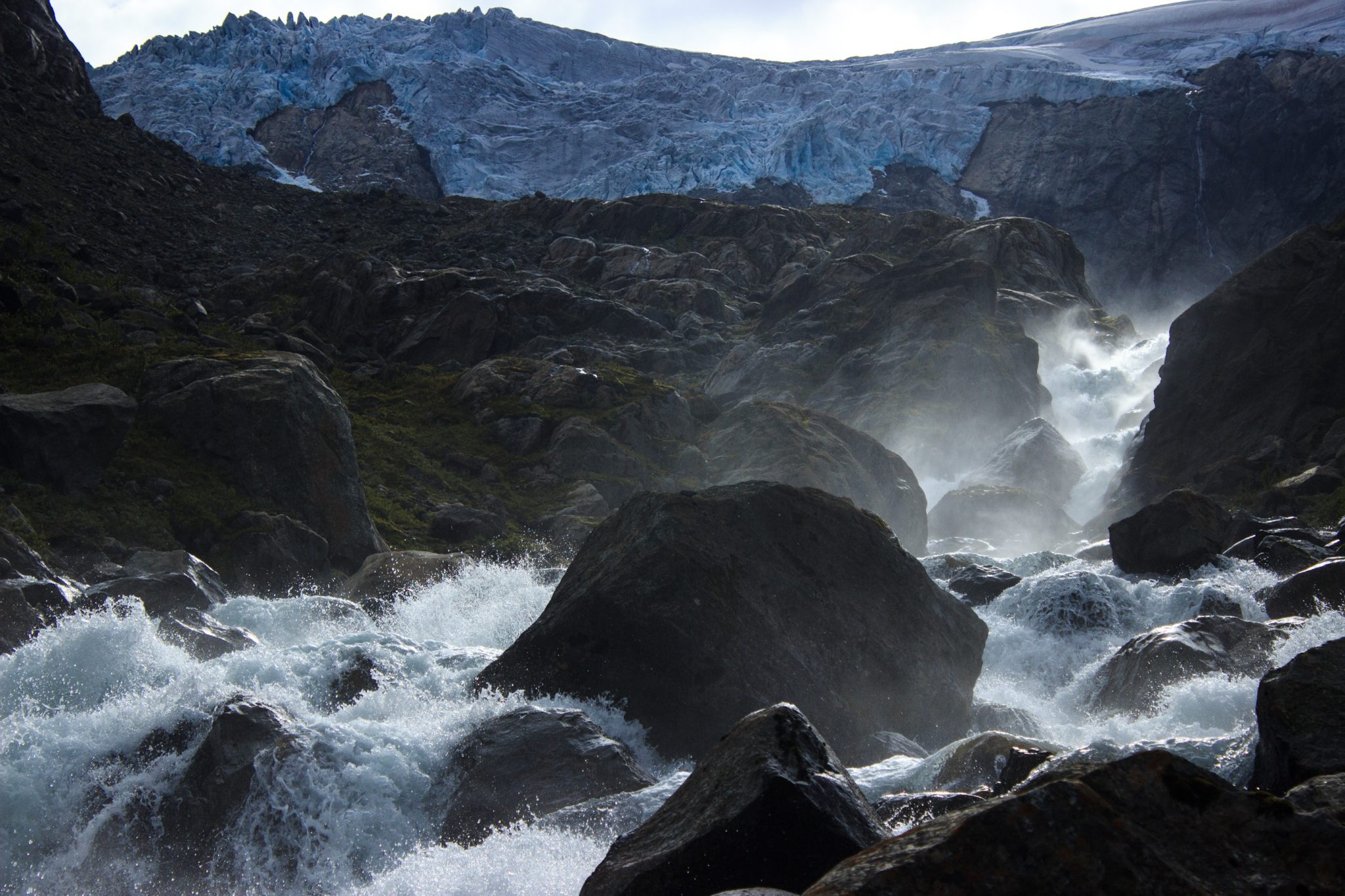 Wandern zum Buarbreen im Folgefonna Nationalpark, Wanderung in der Nähe von Odda mit Aussicht auf den Gletscher Buarbreen und Wasserfälle, Blick auf den Gletscher Buarbreen und den strömenden Fluss, große umliegende Felsen