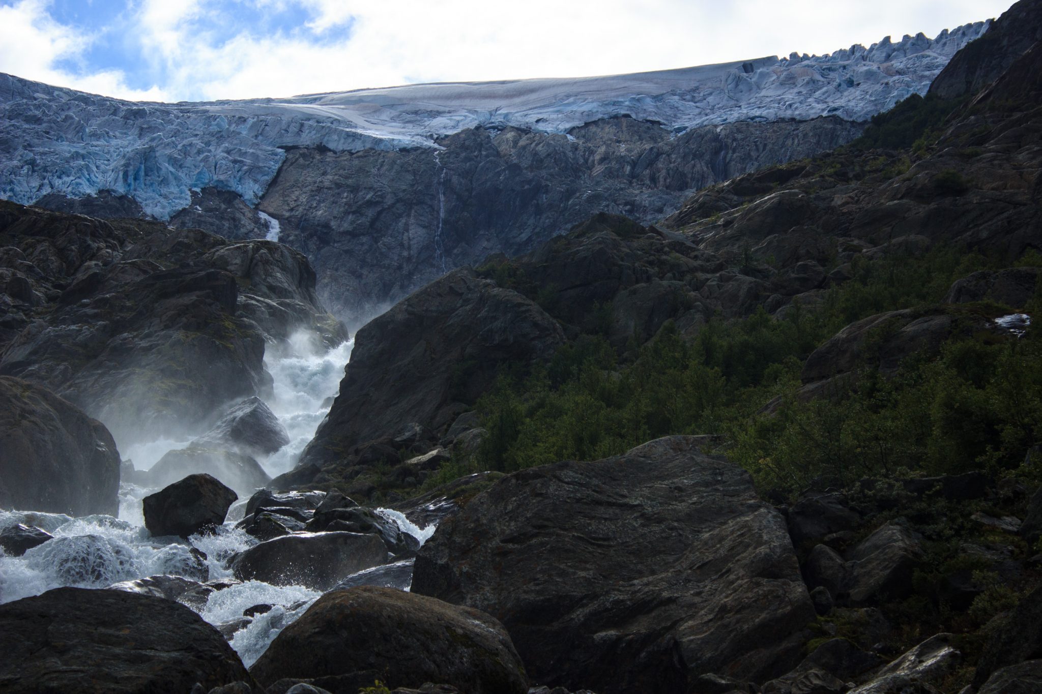 Wandern zum Buarbreen im Folgefonna Nationalpark, Wanderung in der Nähe von Odda mit Aussicht auf den Gletscher Buarbreen und Wasserfälle, Blick auf den Gletscher Buarbreen und den strömenden Fluss, große umliegende Felsen