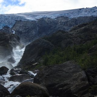 Wandern zum Buarbreen im Folgefonna Nationalpark, Wanderung in der Nähe von Odda mit Aussicht auf den Gletscher Buarbreen und Wasserfälle, Blick auf den Gletscher Buarbreen und den strömenden Fluss, große umliegende Felsen